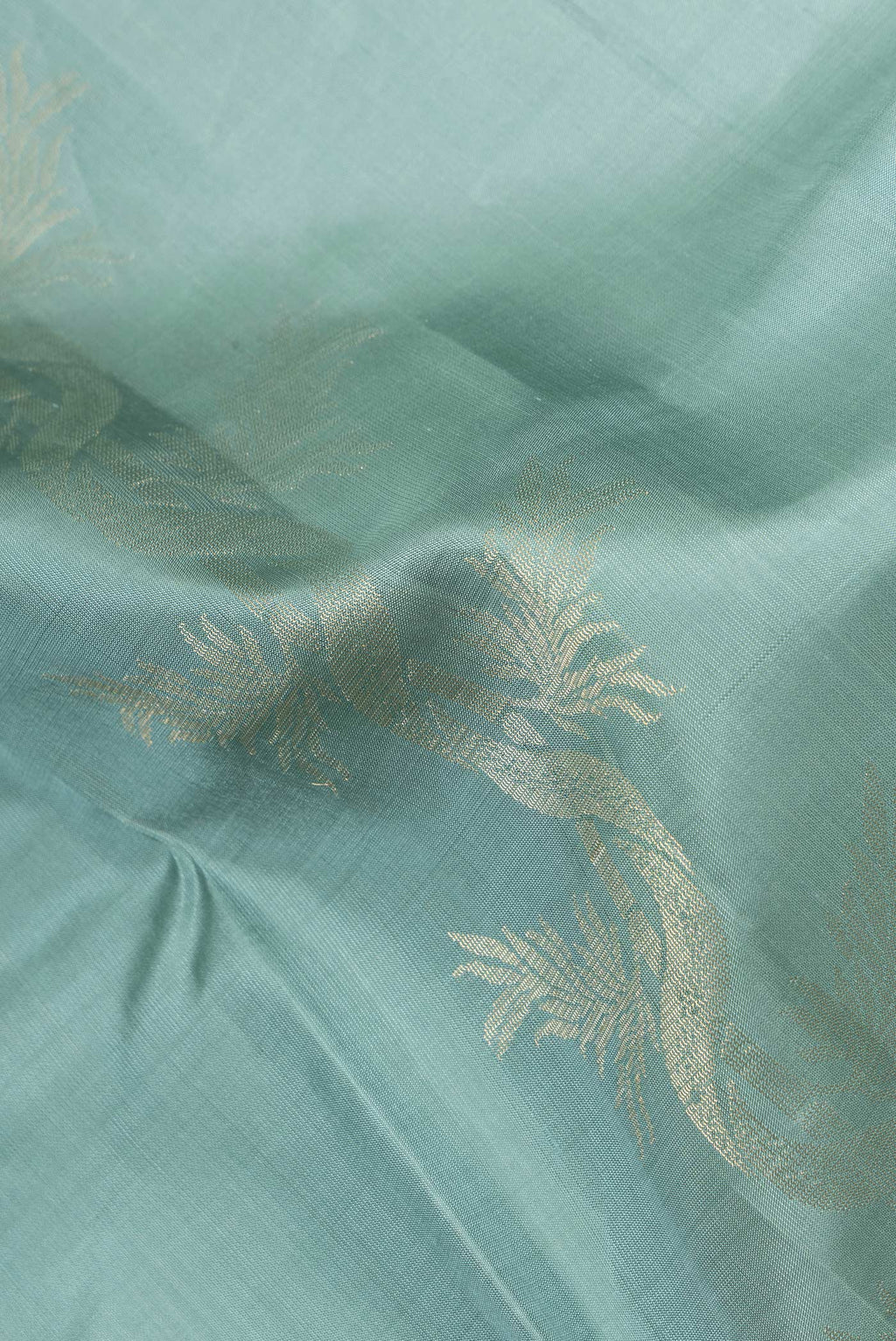 Close up of Pure Silk Mint Green Soft Saree with Zari Butta on the body and Without Border.  displaying folds
