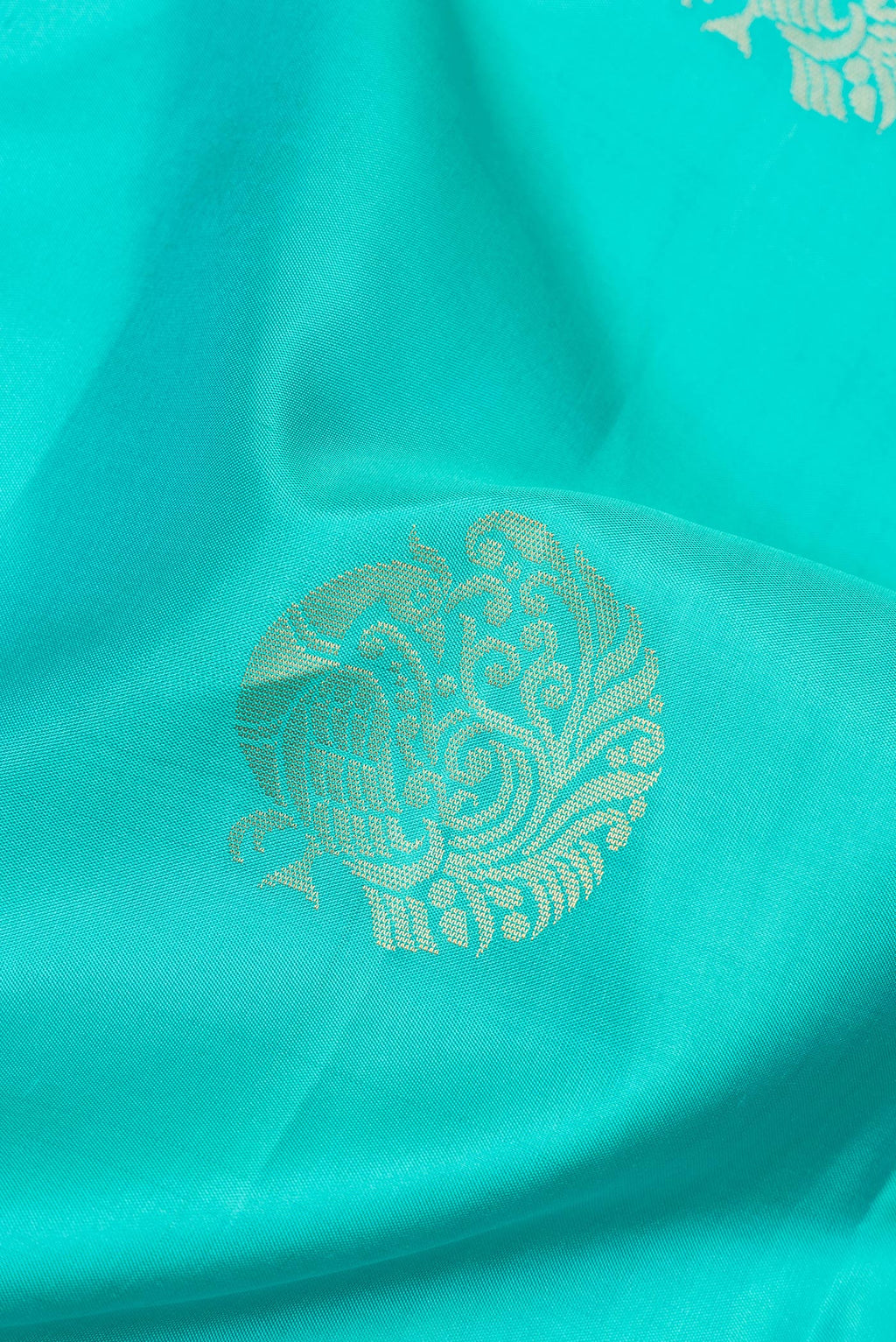Close up of Pure Silk Turquoise Soft Saree with Zari Butta on the body and Zari Border.  displaying folds