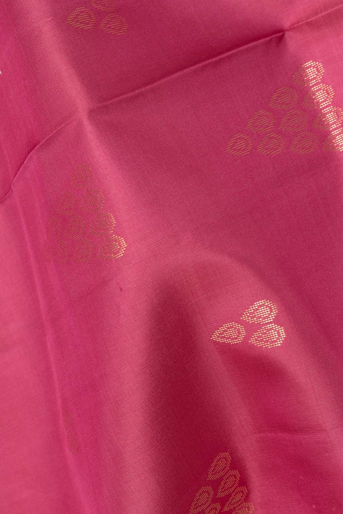 Close up of Pure Silk Coral Soft Saree with Zari Butta on the body and Zari Border.  displaying folds