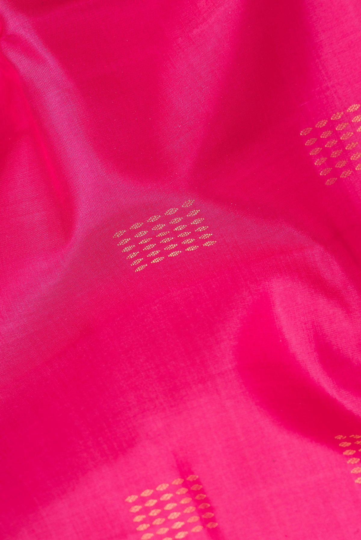 Close up of Pure Silk Pink Soft Saree with Zari Butta on the body and Zari Border.  displaying folds