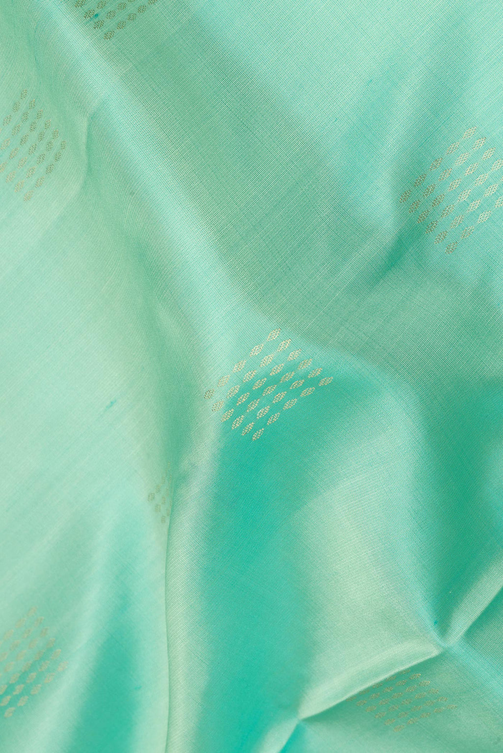 Close up of Pure Silk Pista Green Dual Tone Soft Saree with Zari Butta on the body and Zari Border.  displaying folds
