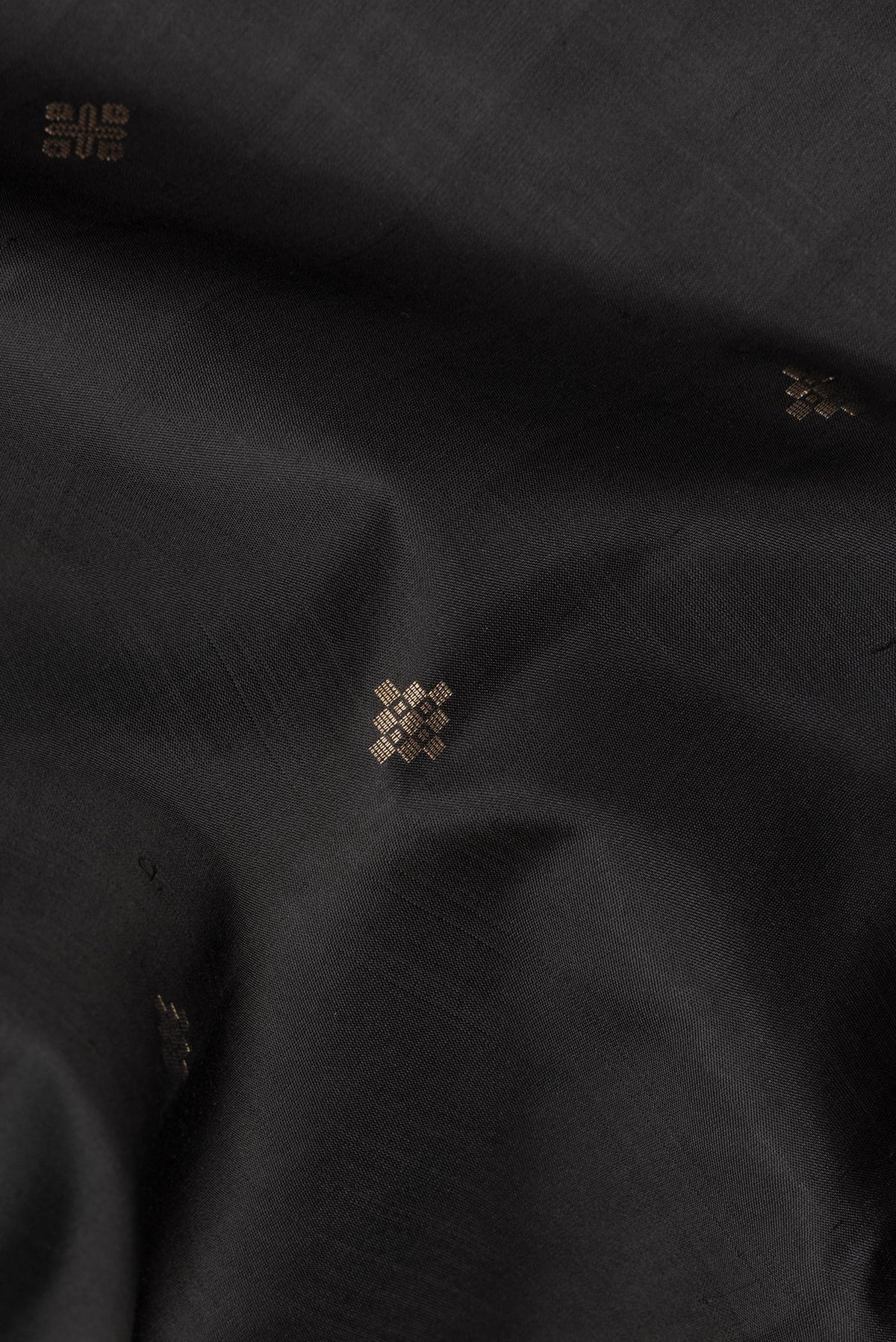 Close up of Pure Silk Black Soft Saree with Zari Butta on the body and Zari Border.  displaying folds