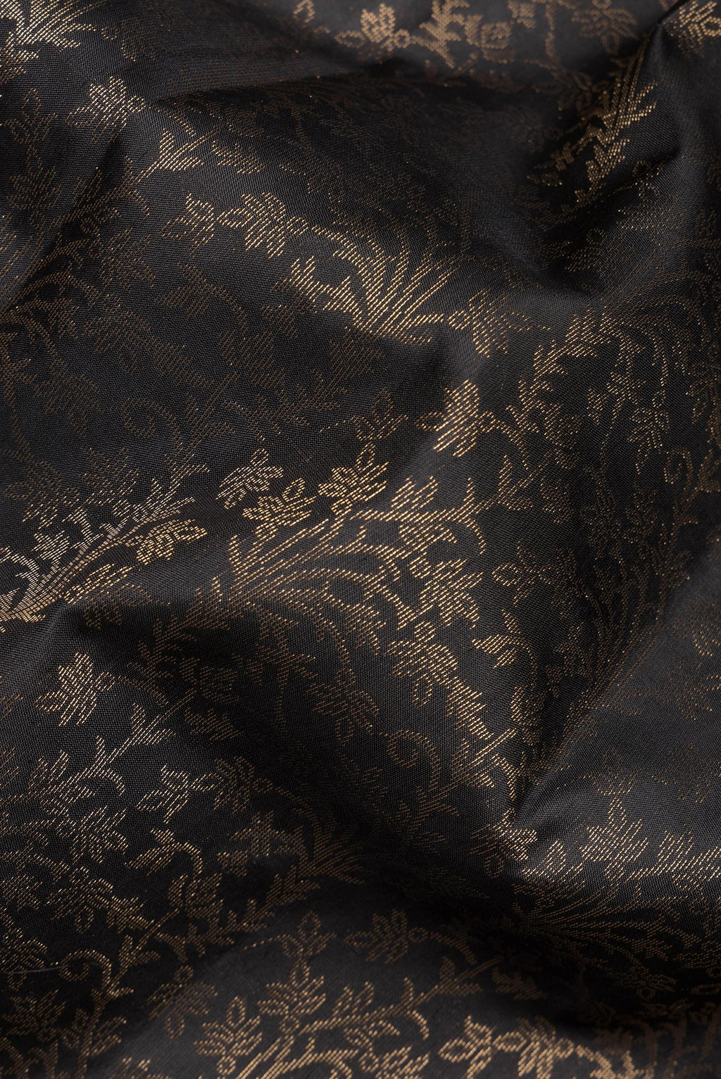 Close up of Pure Silk Black Soft Saree with Zari Brocade on the body and Zari Border.  displaying folds