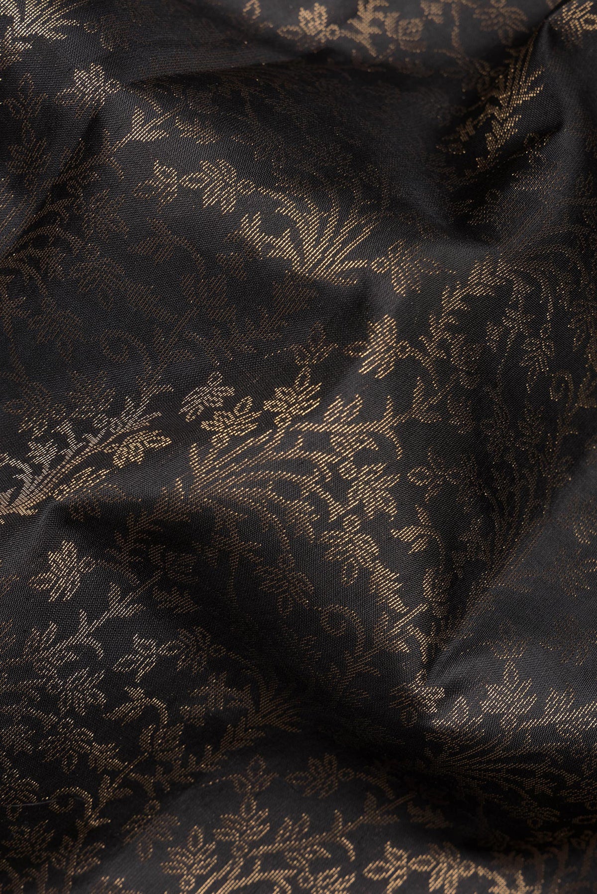 Close up of Pure Silk Black Soft Saree with Zari Brocade on the body and Zari Border.  displaying folds