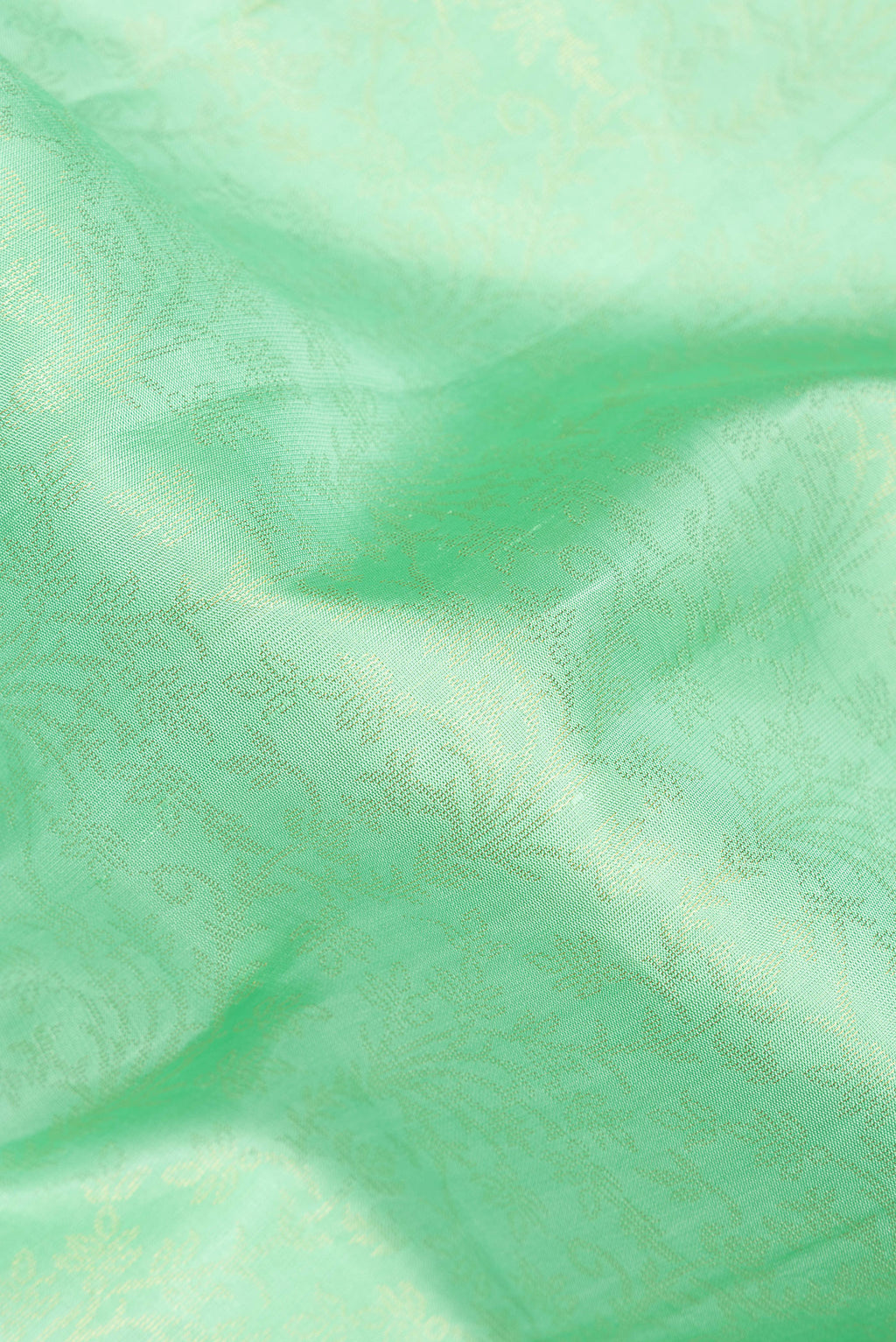 Close up of Pure Silk Mint Green Soft Saree with Zari Brocade on the body and Zari Border.  displaying folds