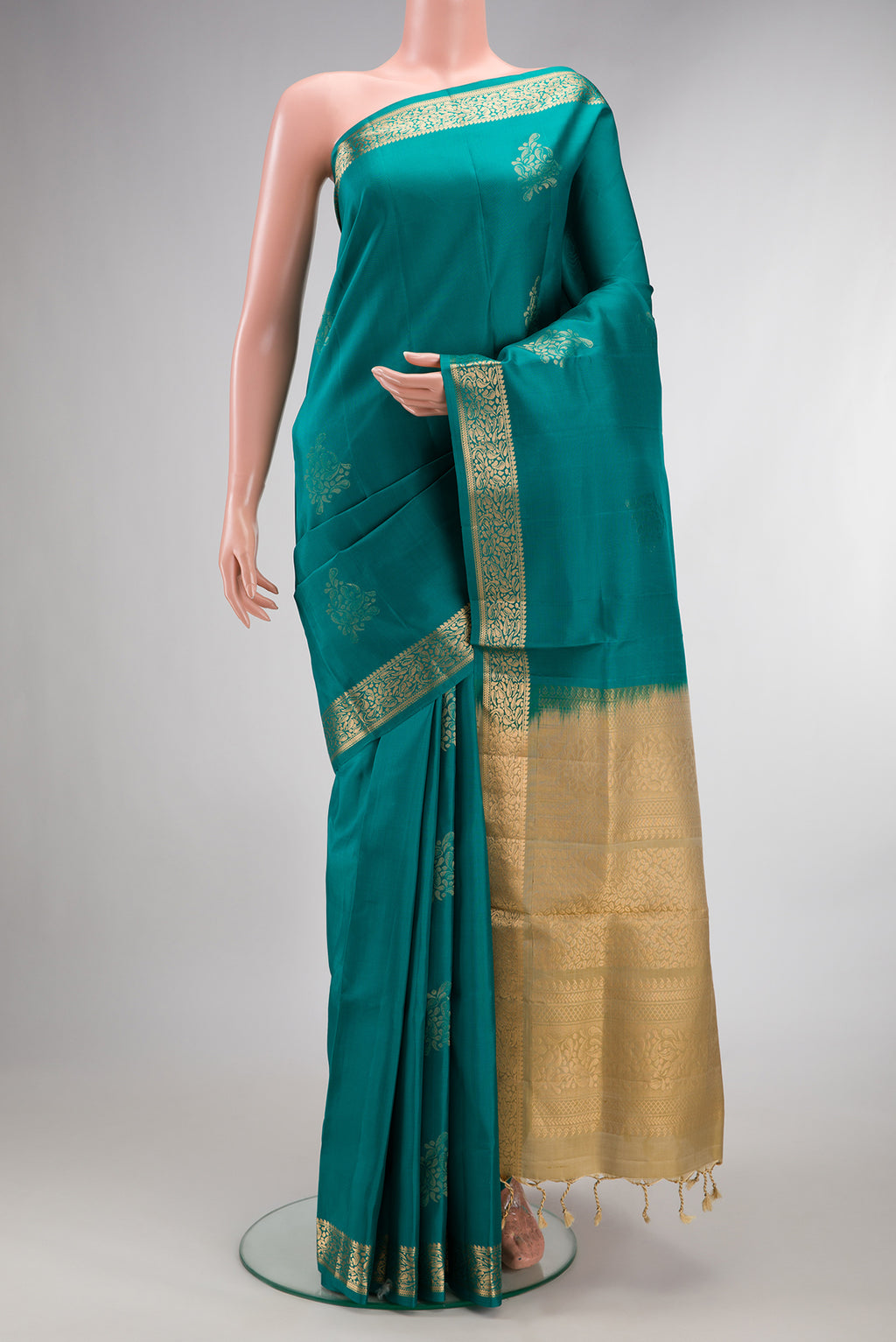 Pure Silk Teal Soft Saree with Zari Butta on the body and Zari Border.  displayed on a mannequin