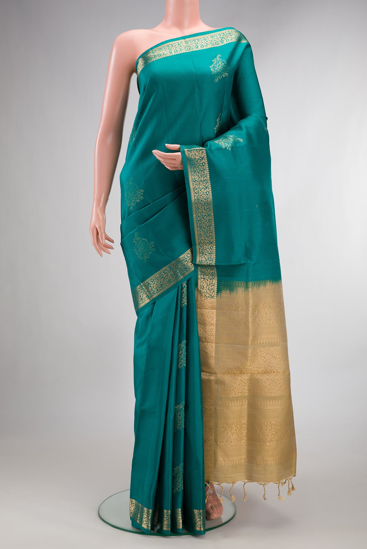Pure Silk Teal Soft Saree with Zari Butta on the body and Zari Border.  displayed on a mannequin