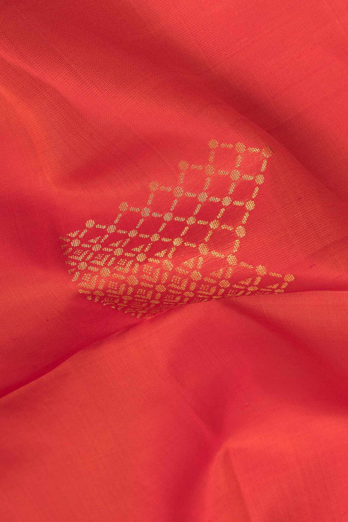 Close up of Pure Silk Orange Dual Tone Soft Saree with Zari Butta on the body and Zari Border.  displaying folds