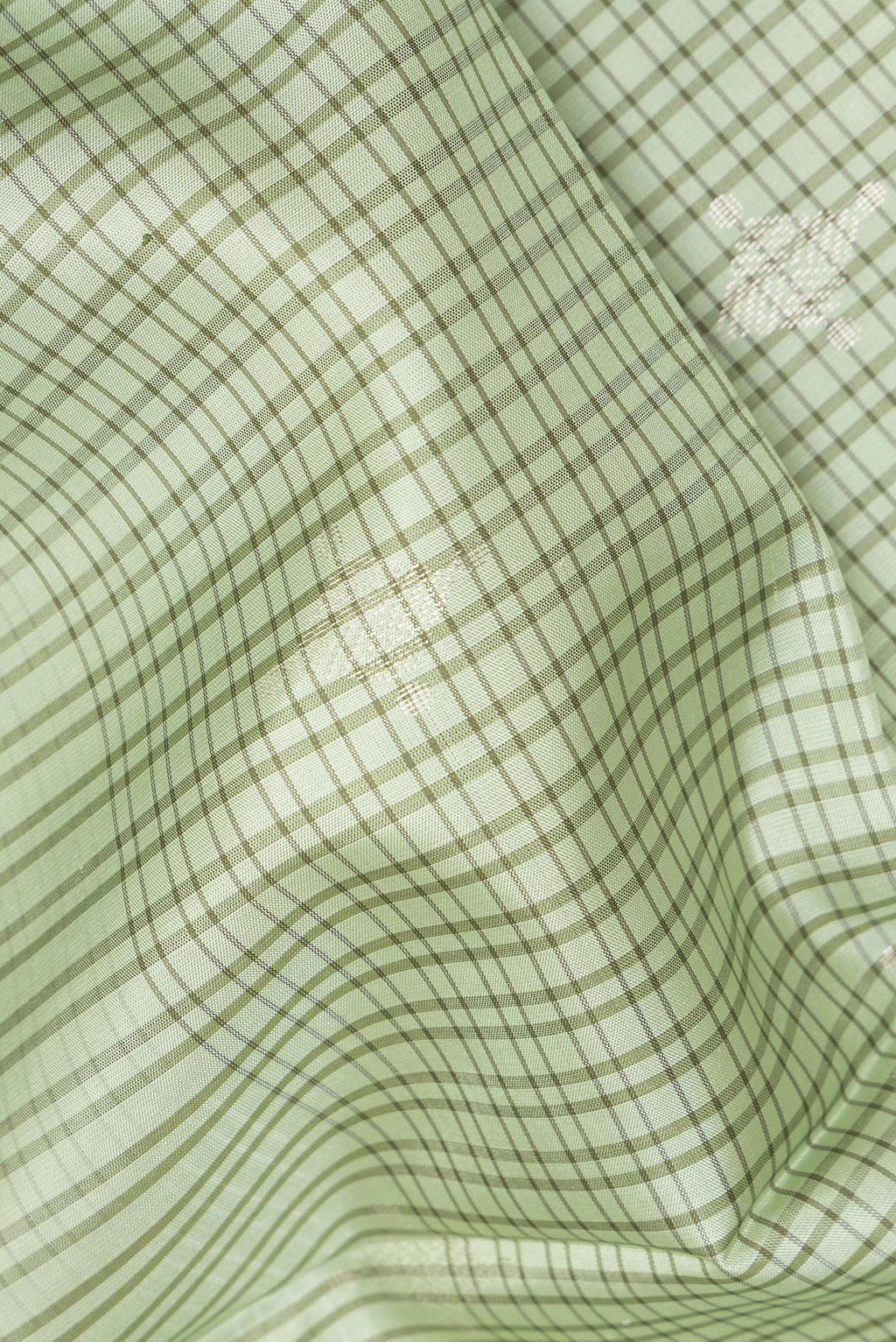 Close up of Pure Silk Pista Green Dual Tone Soft Saree with Checked design on the body and Thread Border.  displaying folds
