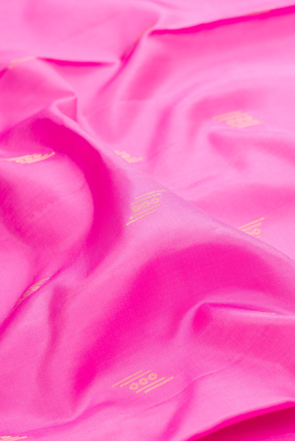 Close up of Pure Silk Pink Soft Saree with Zari Butta on the body and Zari Border.  displaying folds