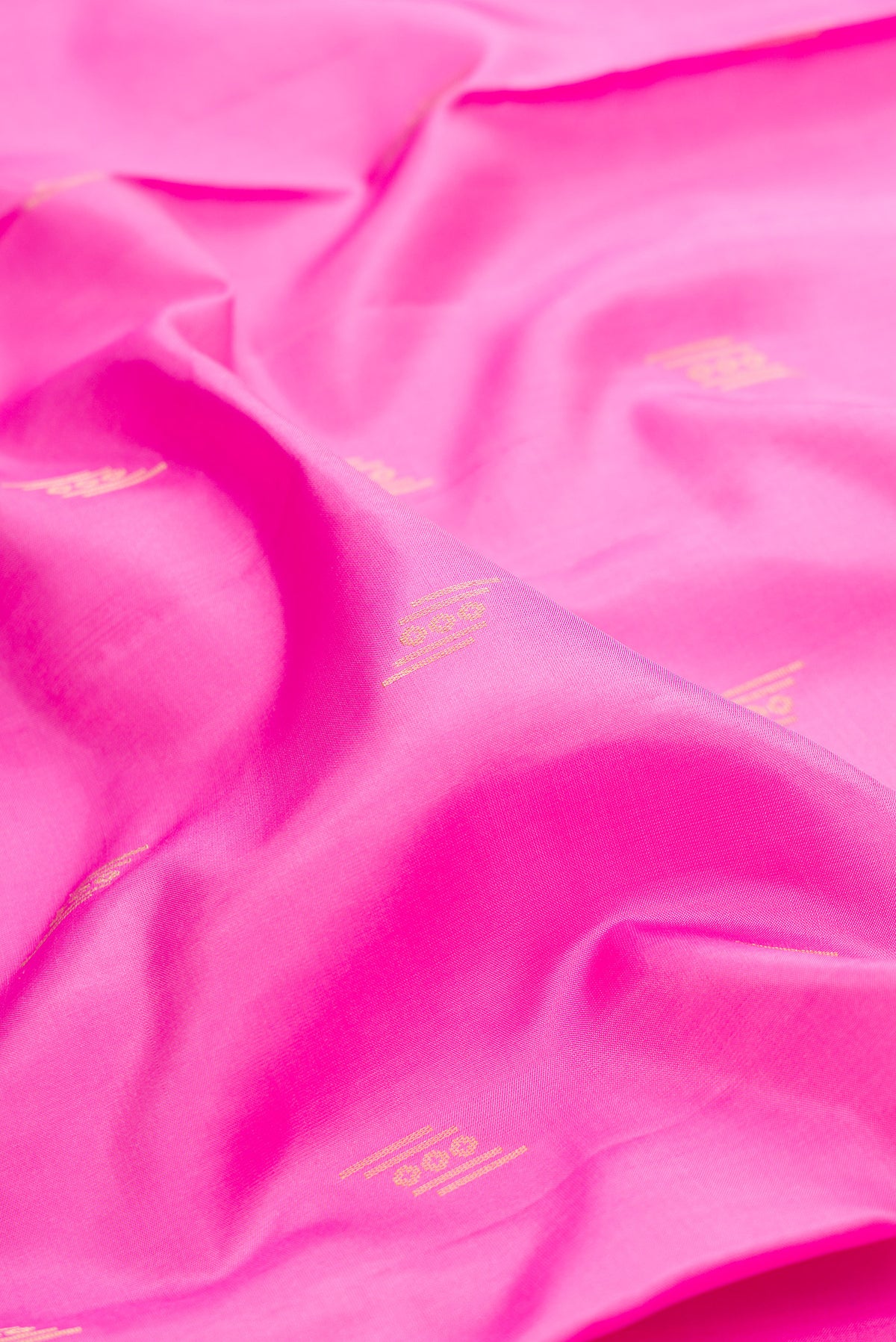 Close up of Pure Silk Pink Soft Saree with Zari Butta on the body and Zari Border.  displaying folds