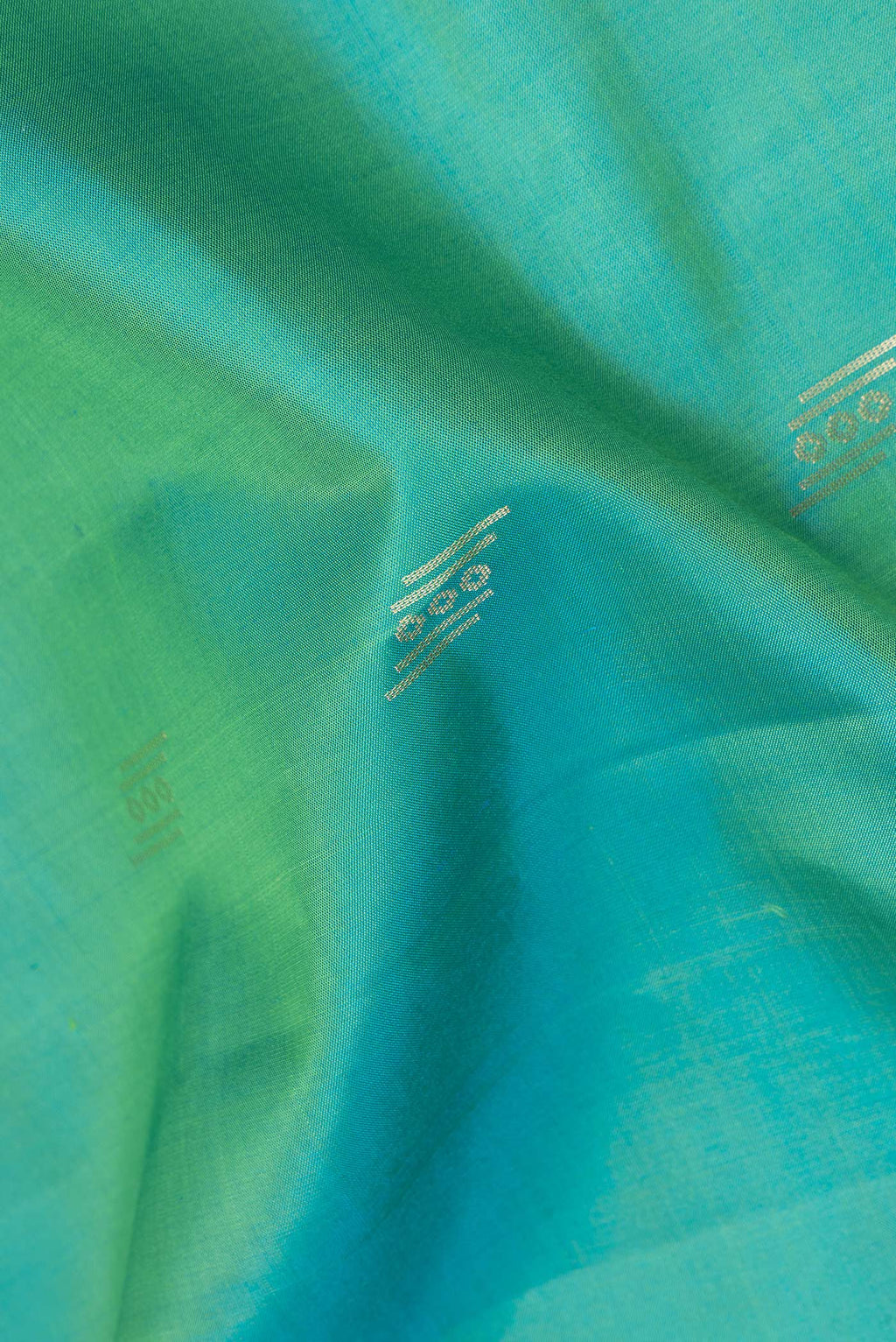Close up of Pure Silk Sea Green Dual Tone Soft Saree with Zari Butta on the body and Zari Border.  displaying folds