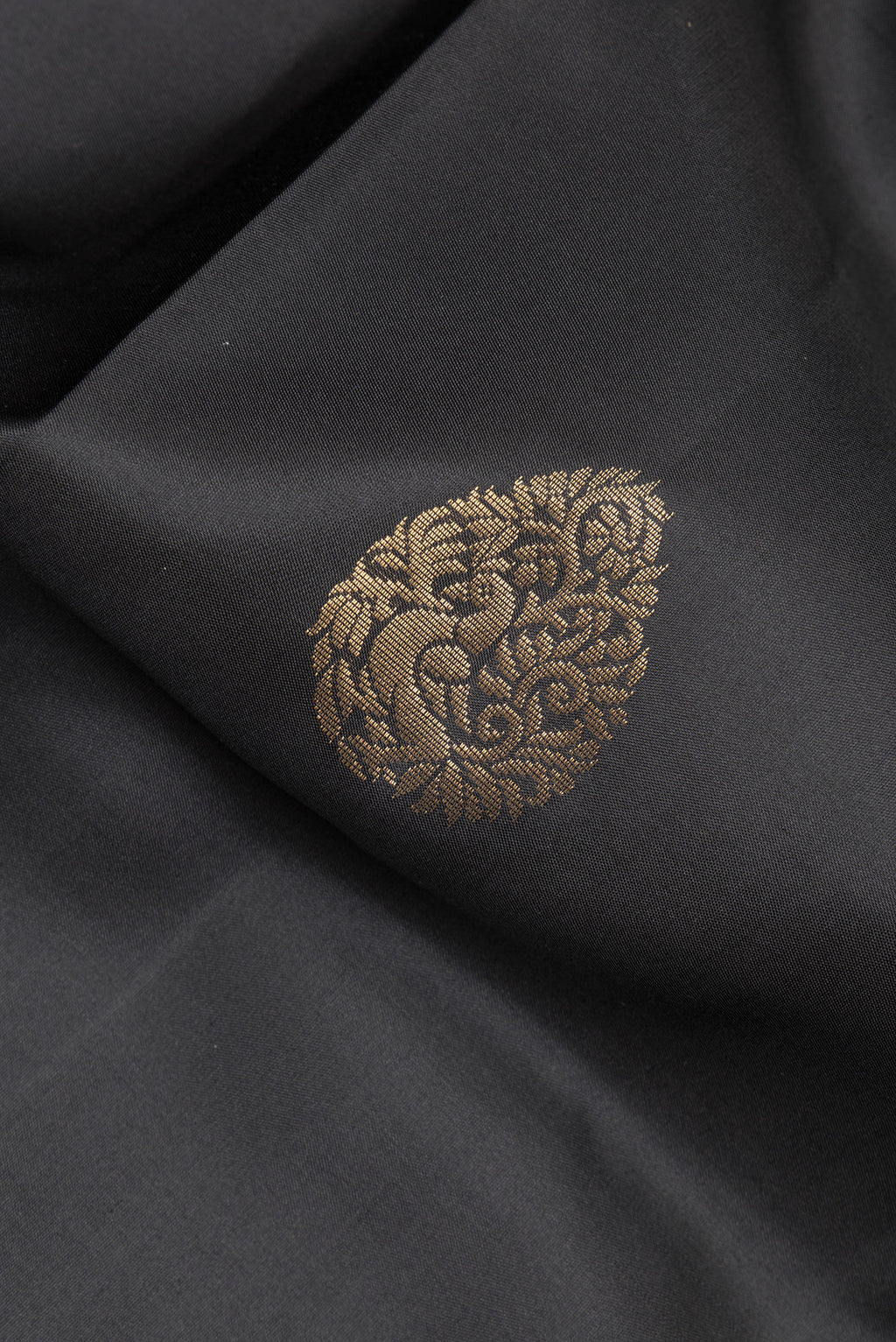 Close up of Pure Silk Black Soft Saree with Zari Butta on the body and Zari Border.  displaying folds