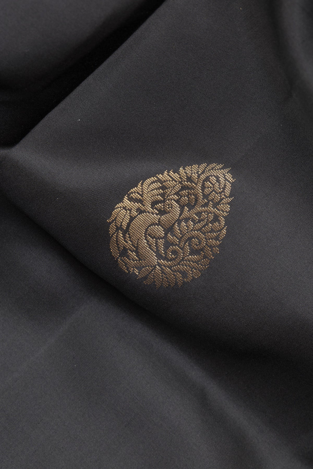 Close up of Pure Silk Black Soft Saree with Zari Butta on the body and Zari Border.  displaying folds