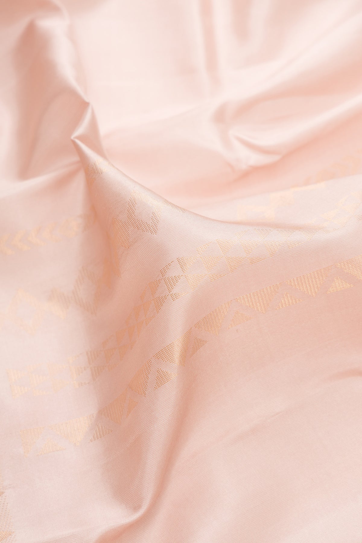 Close up of Pure Silk Rose Gold Dual Tone Kanchipuram Saree with Stripes on the body and Zari Border.  displaying folds