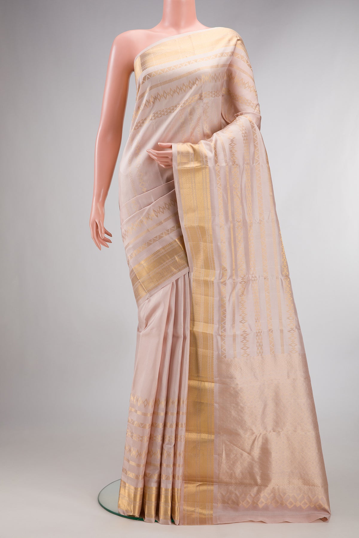 Pure Silk Rose Gold Dual Tone Kanchipuram Saree with Stripes on the body and Zari Border.  displayed on a mannequin
