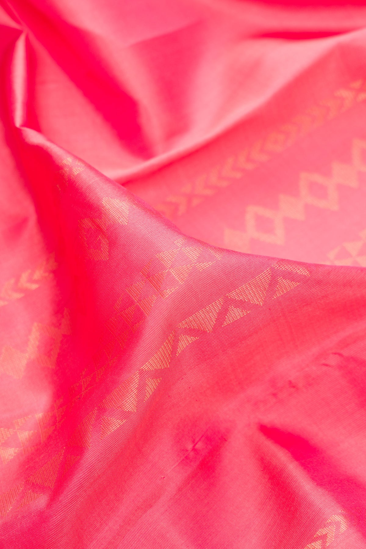 Close up of Pure Silk Coral Kanchipuram Saree with Stripes on the body and Zari Border.  displaying folds