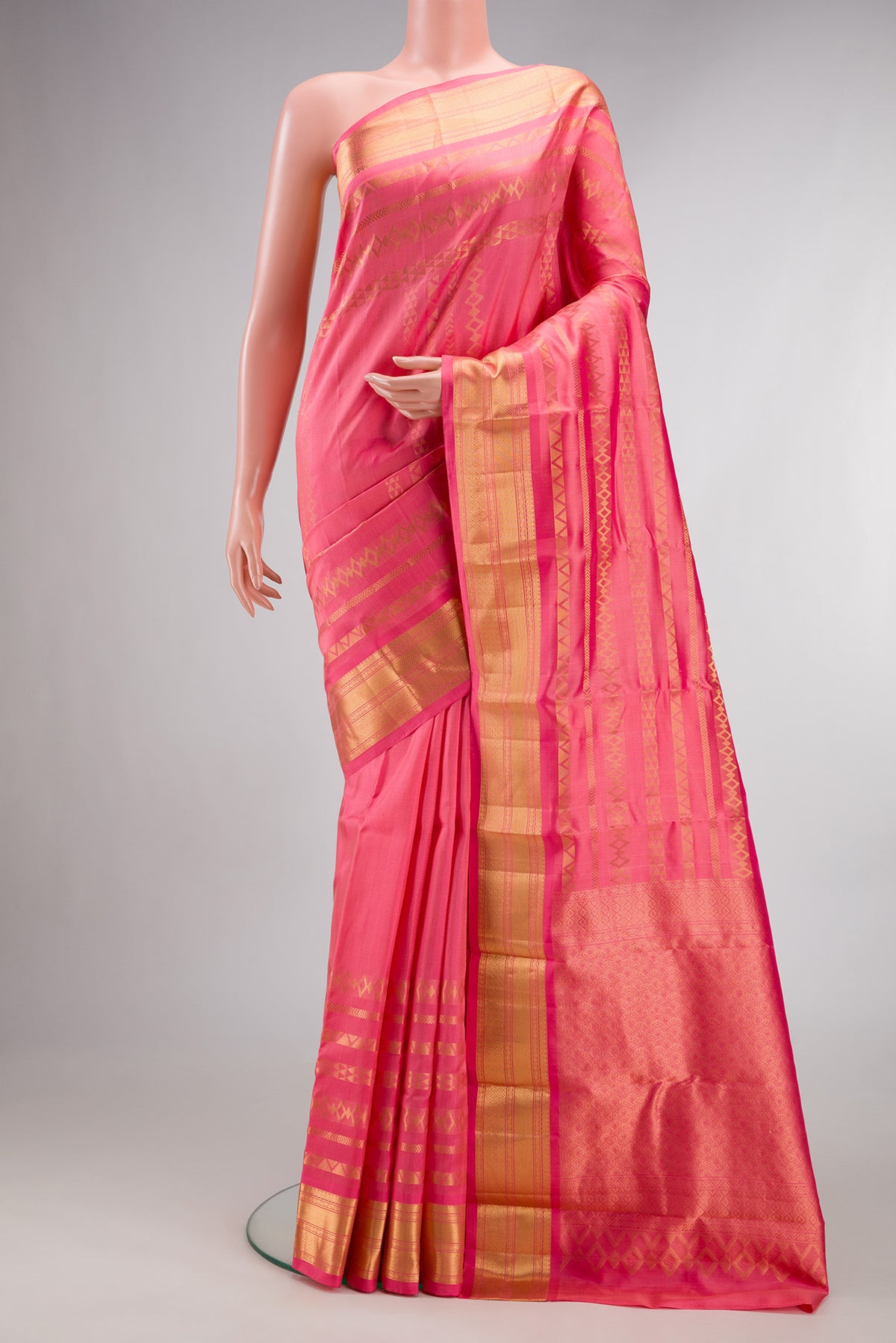Pure Silk Coral Kanchipuram Saree with Stripes on the body and Zari Border.  displayed on a mannequin