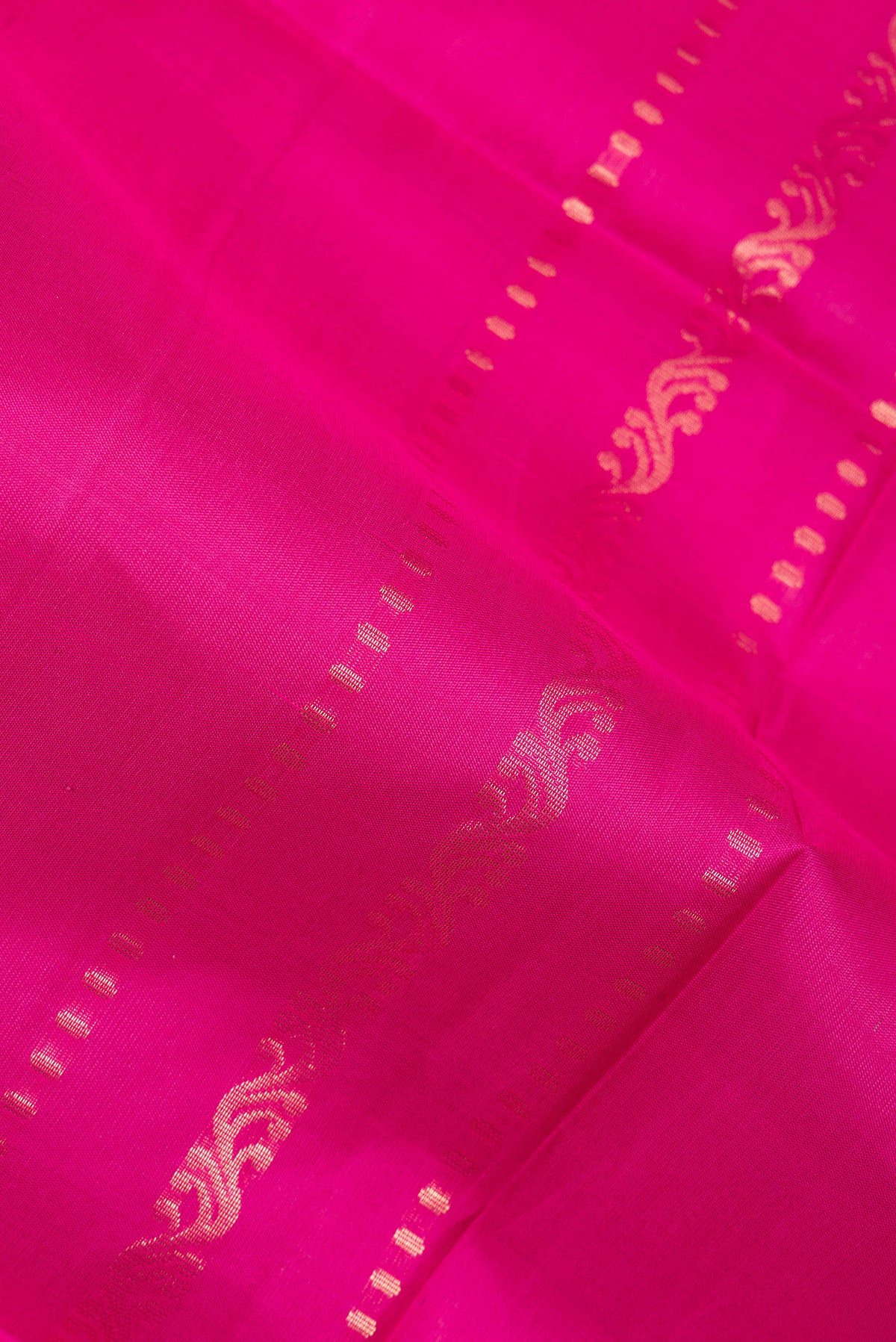 Close up of Pure Silk Dark Pink Soft Saree with Zari Butta on the body and Zari Border.  displaying folds