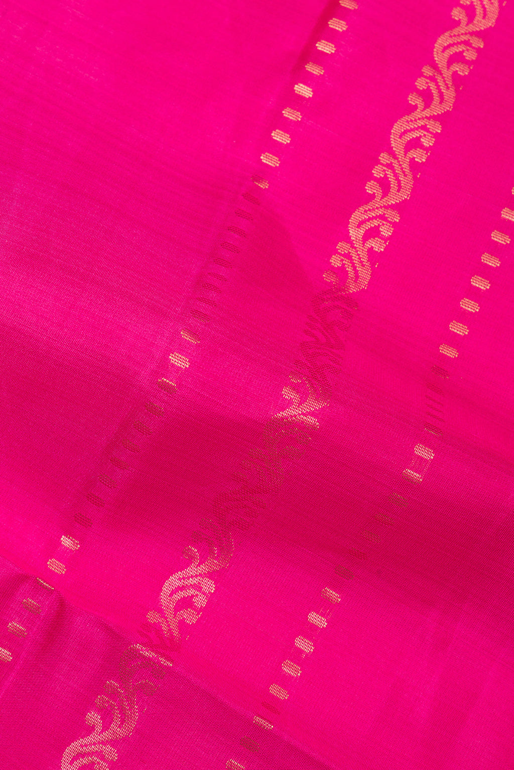 Close up of Pure Silk Dark Pink Soft Saree with Zari Butta on the body and Zari Border.  displaying folds