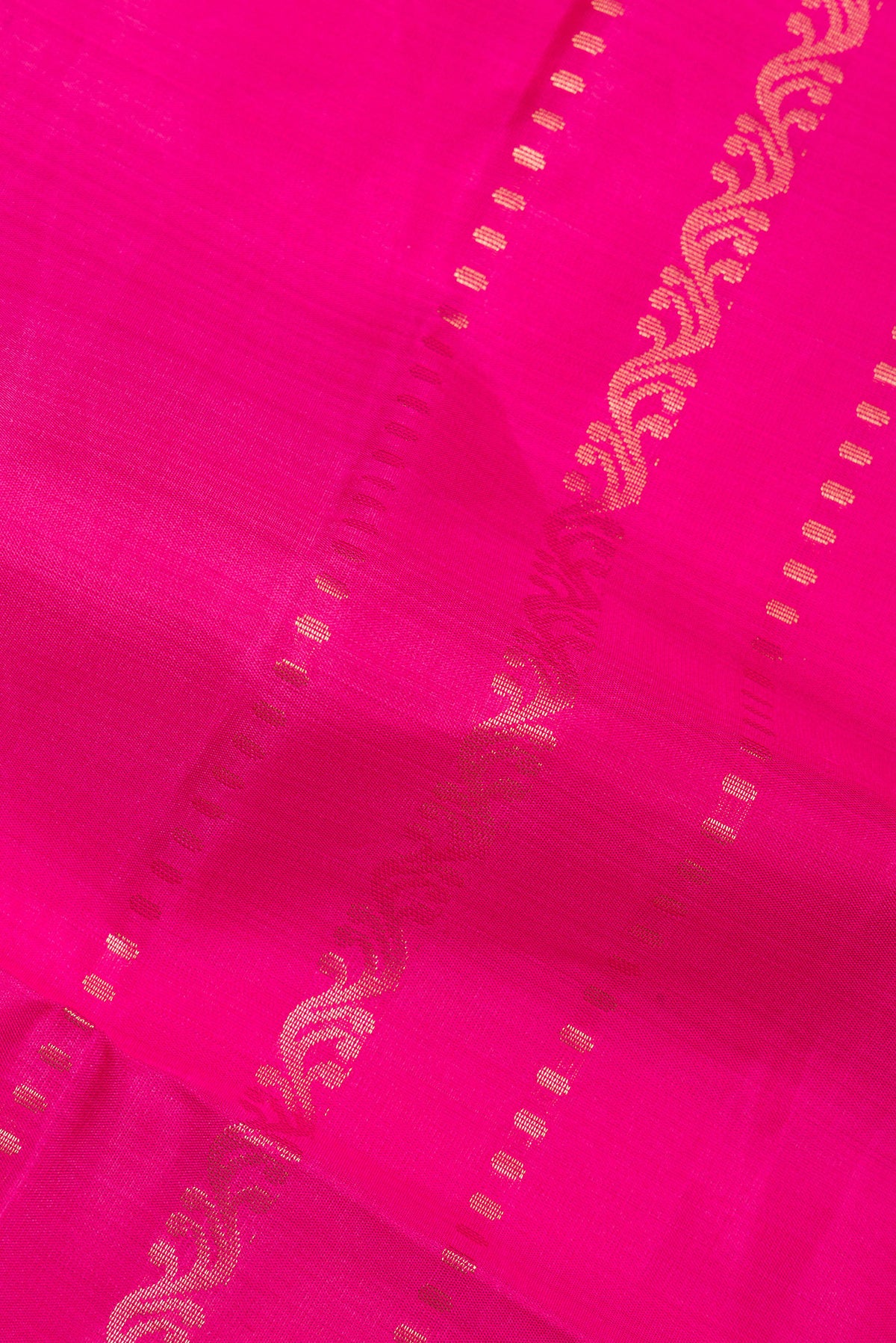 Close up of Pure Silk Dark Pink Soft Saree with Zari Butta on the body and Zari Border.  displaying folds