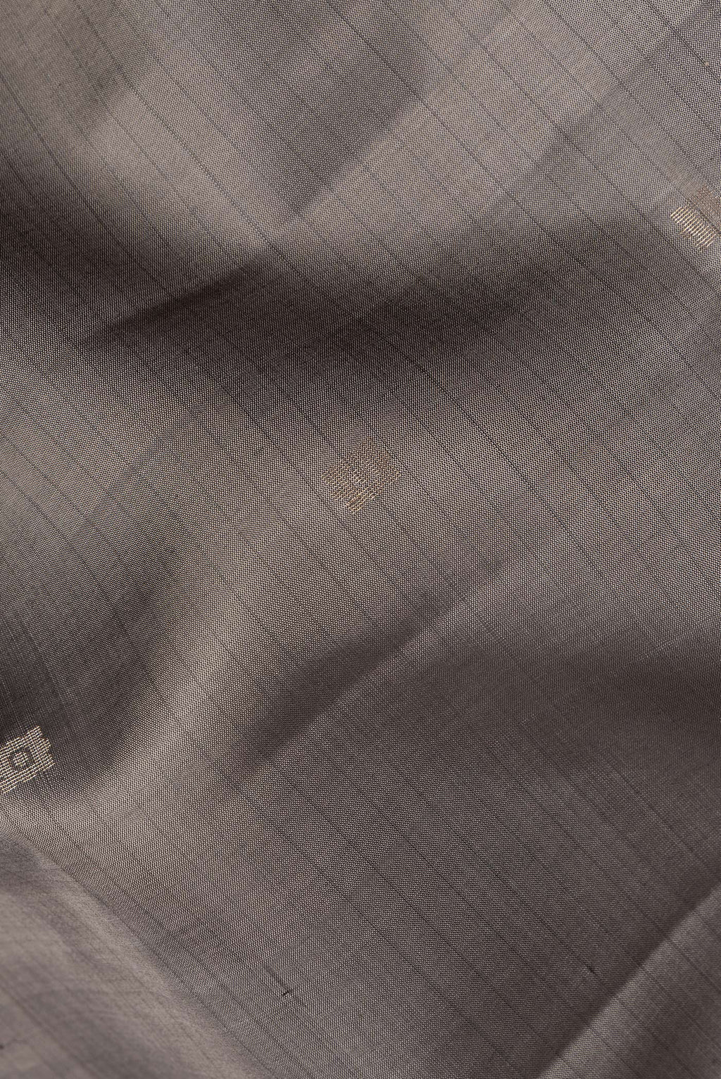Close up of Pure Silk Grey Soft Saree with Zari Butta on the body and Fancy Border.  displaying folds