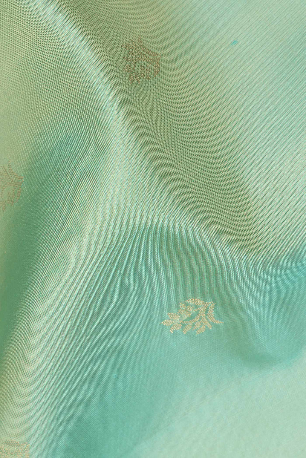 Close up of Pure Silk Pista Green Soft Saree with Zari Butta on the body and Zari Border.  displaying folds
