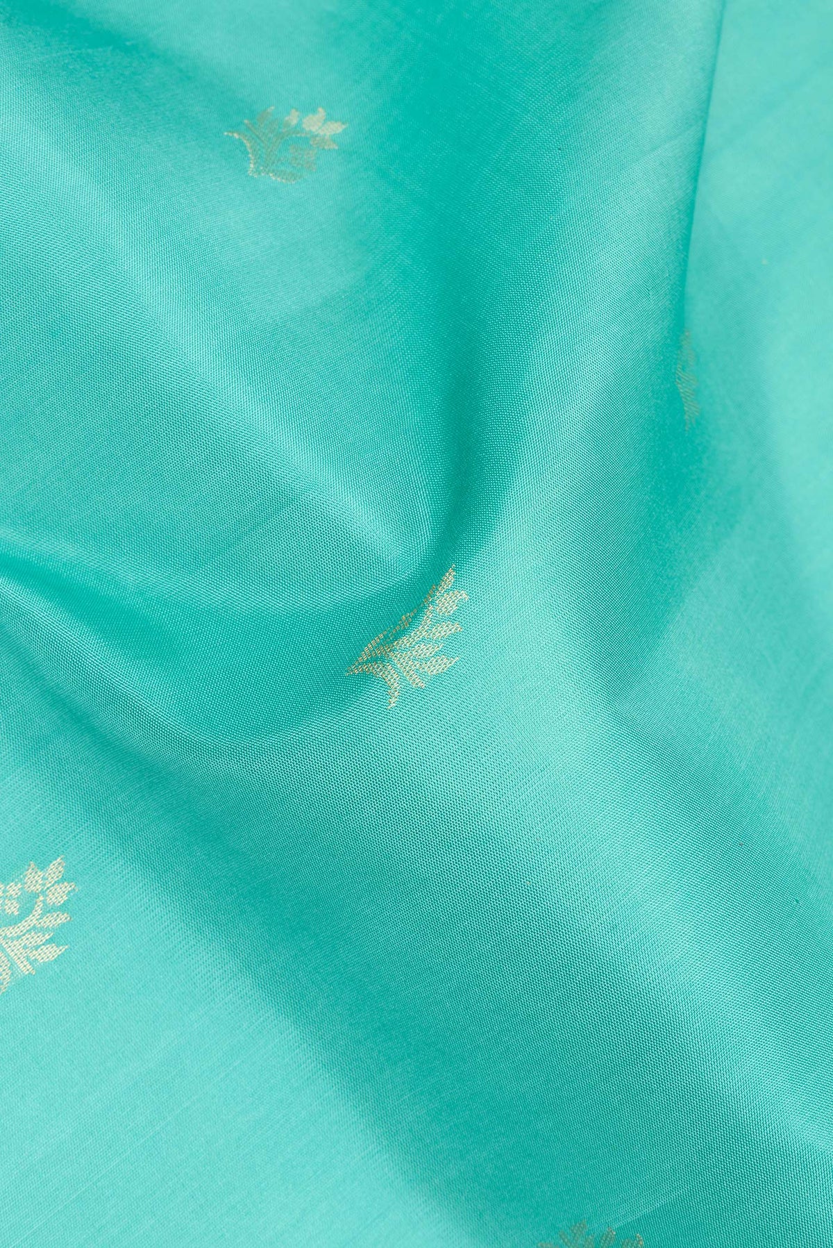Close up of Pure Silk Sea Green Soft Saree with Zari Butta on the body and Zari Border.  displaying folds