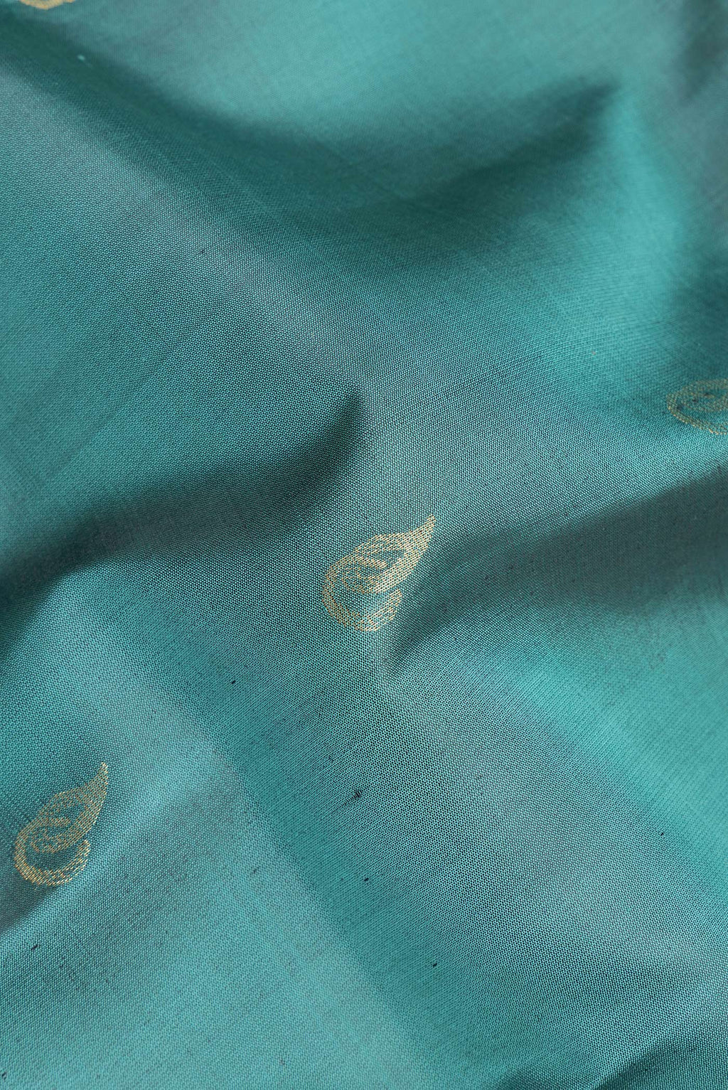 Close up of Pure Silk Green Soft Saree with Zari Butta on the body and Zari Border.  displaying folds