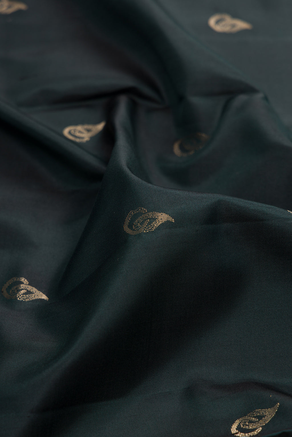 Close up of Pure Silk Bottle Green Soft Saree with Zari Butta on the body and Zari Border.  displaying folds