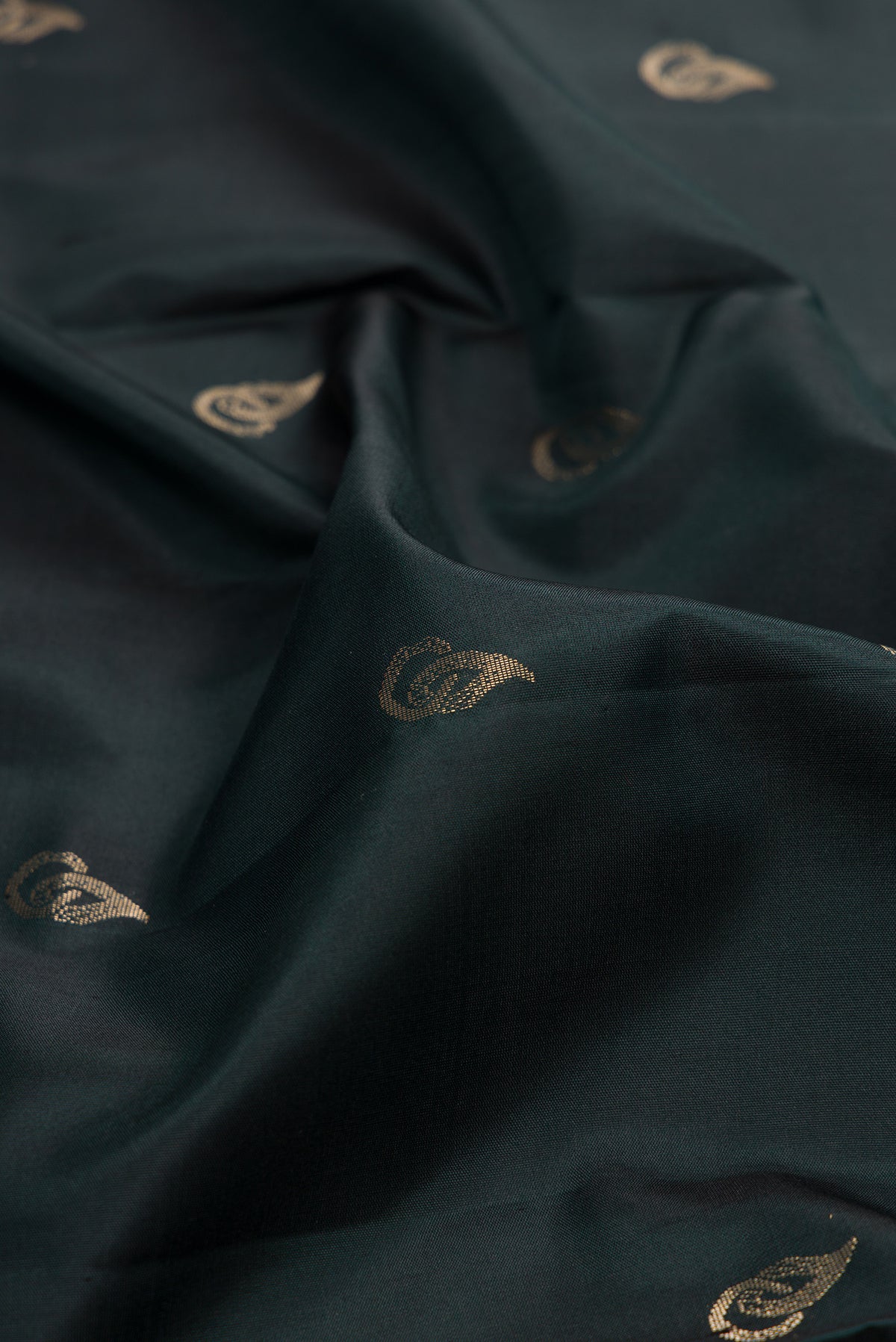 Close up of Pure Silk Bottle Green Soft Saree with Zari Butta on the body and Zari Border.  displaying folds