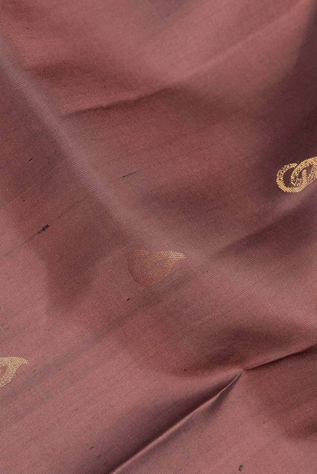 Close up of Pure Silk Brown Soft Saree with Zari Butta on the body and Zari Border.  displaying folds