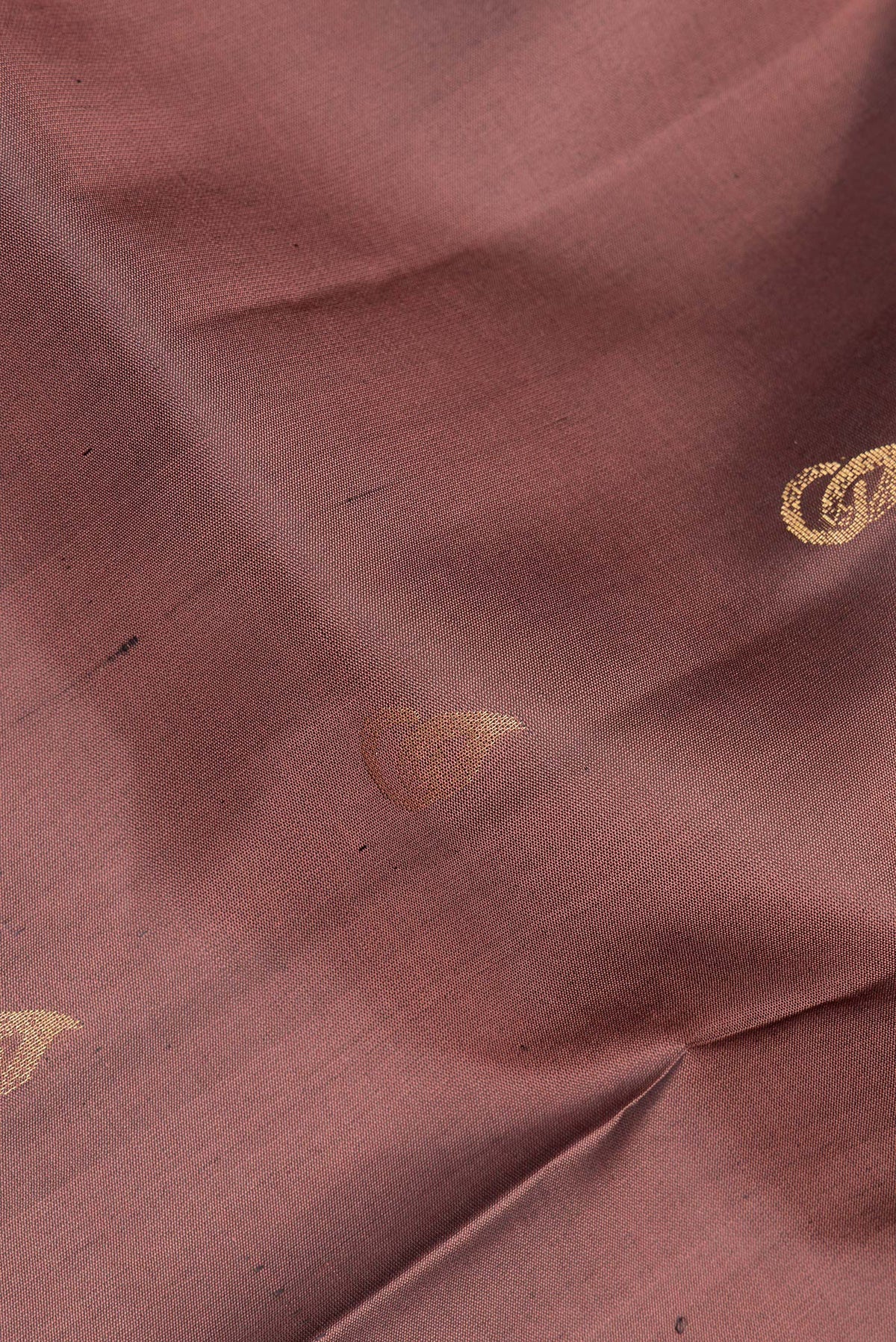 Close up of Pure Silk Brown Soft Saree with Zari Butta on the body and Zari Border.  displaying folds