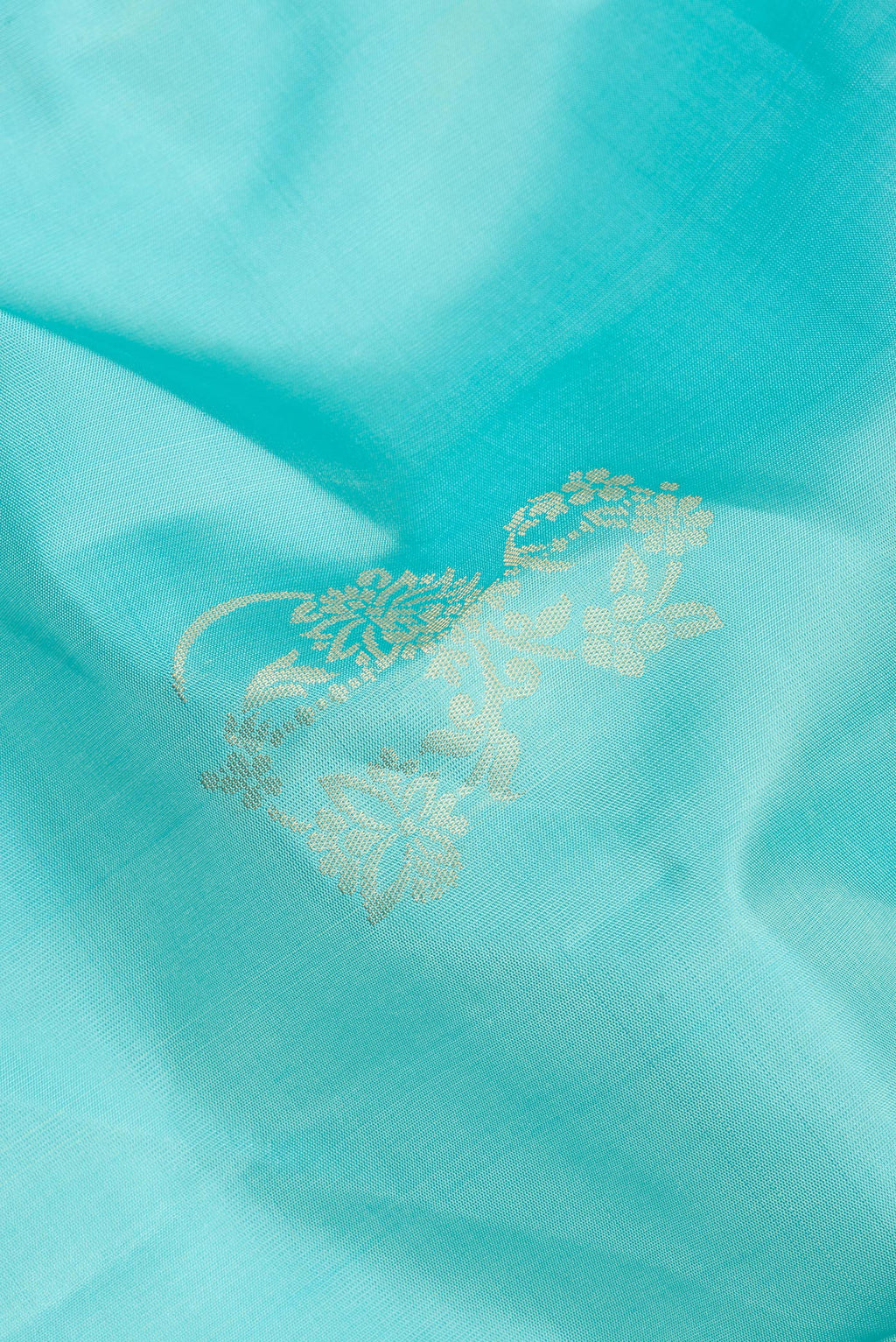 Close up of Pure Silk Sky Blue Soft Saree with Zari Butta on the body and Zari Border.  displaying folds