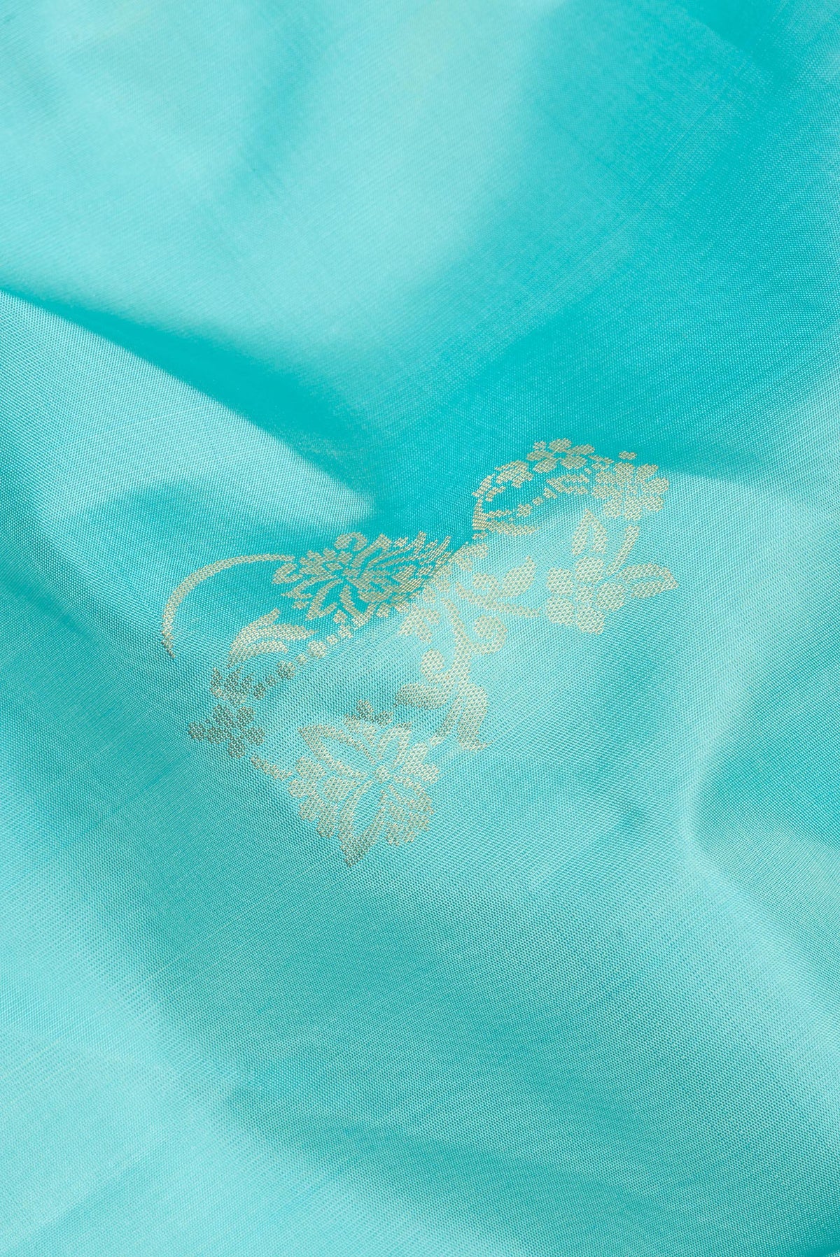 Close up of Pure Silk Sky Blue Soft Saree with Zari Butta on the body and Zari Border.  displaying folds