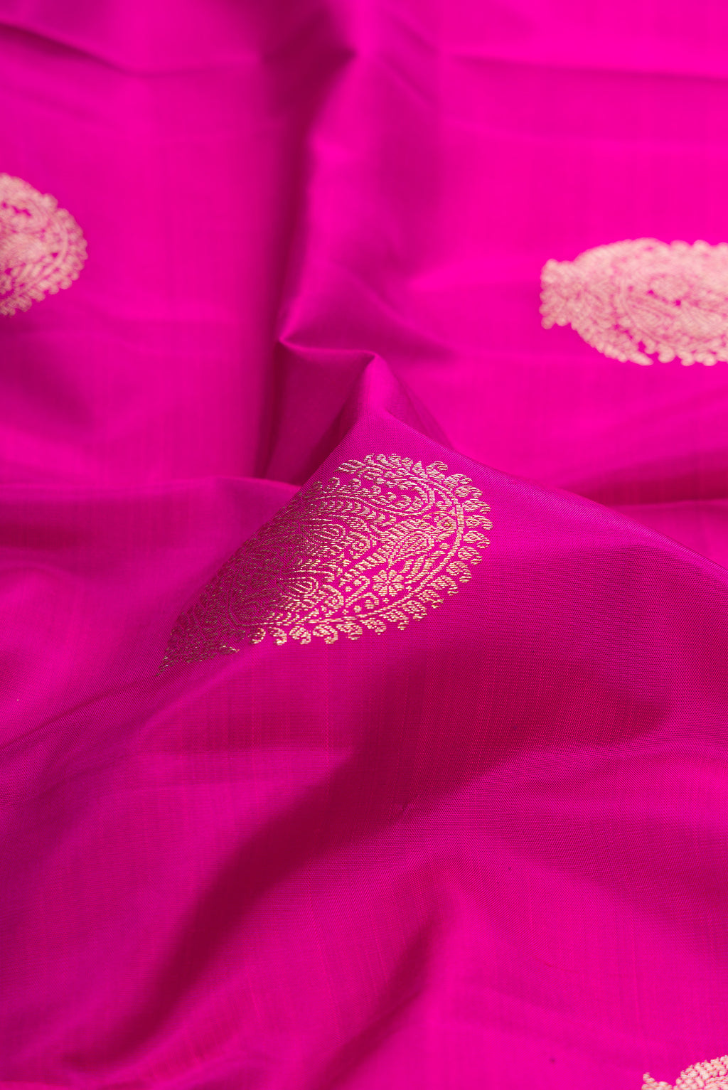 Close up of Pure Silk Pink Kanjivaram Saree with Zari Butta on the body and Fancy Border.  displaying folds