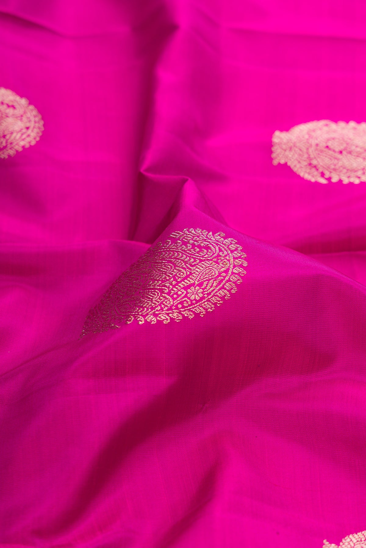 Close up of Pure Silk Pink Kanjivaram Saree with Zari Butta on the body and Fancy Border.  displaying folds