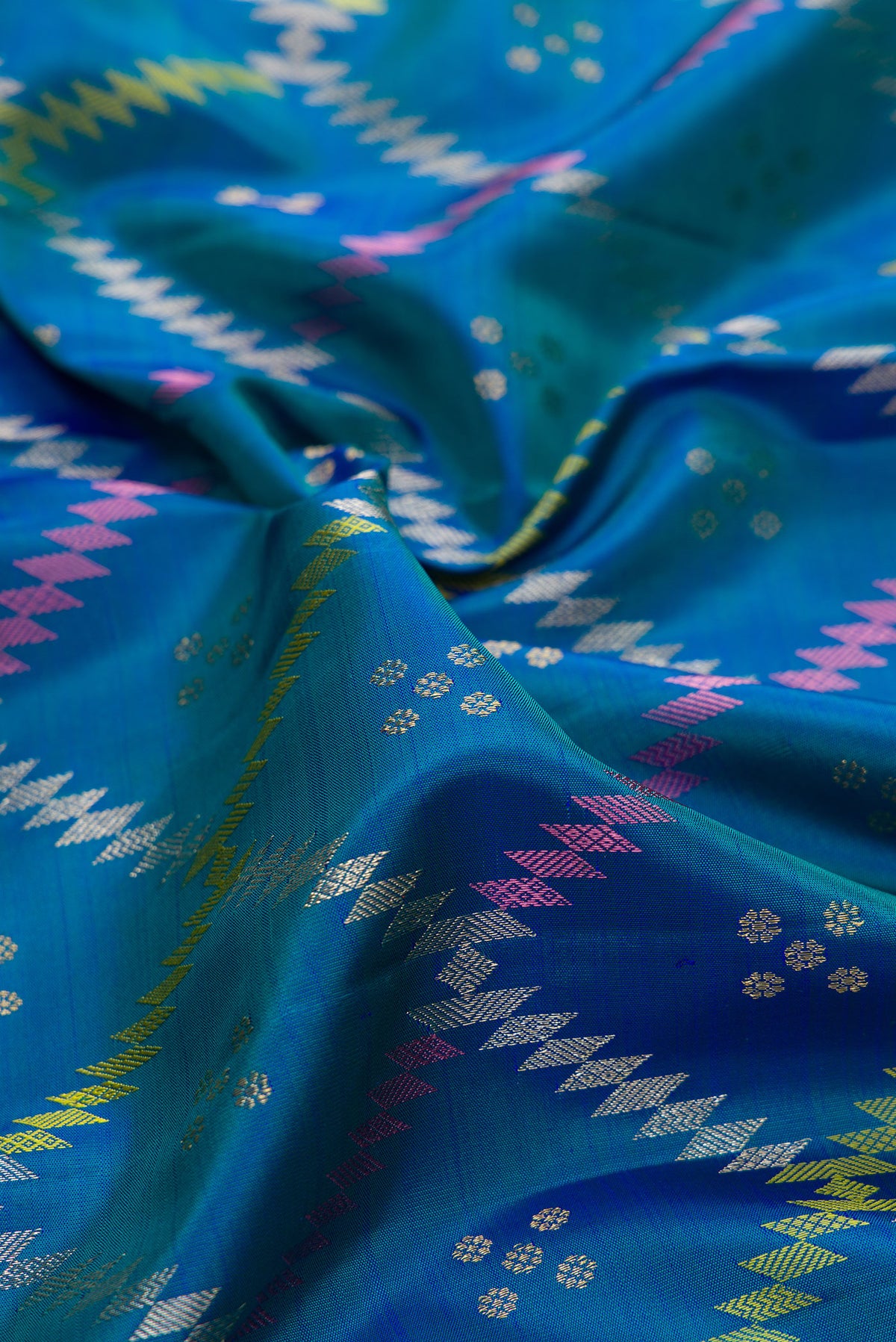 Close up of Pure Silk Peacock Blue Dual Tone Kanjivaram Saree with Zari Butta on the body and Zari Border.  displaying folds