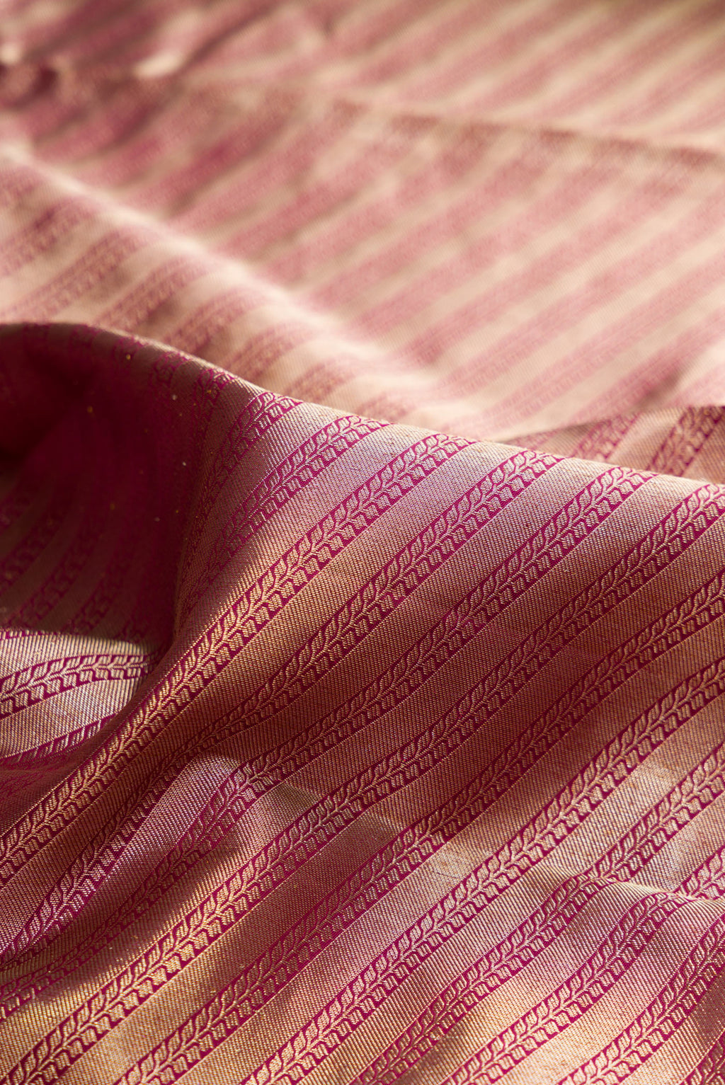 Close up of Pure Silk Magenta Kanjivaram Saree with Zari Brocade on the body and Fancy Border.  displaying folds