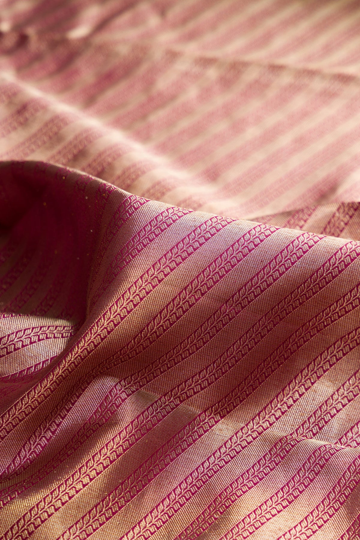 Close up of Pure Silk Magenta Kanjivaram Saree with Zari Brocade on the body and Fancy Border.  displaying folds