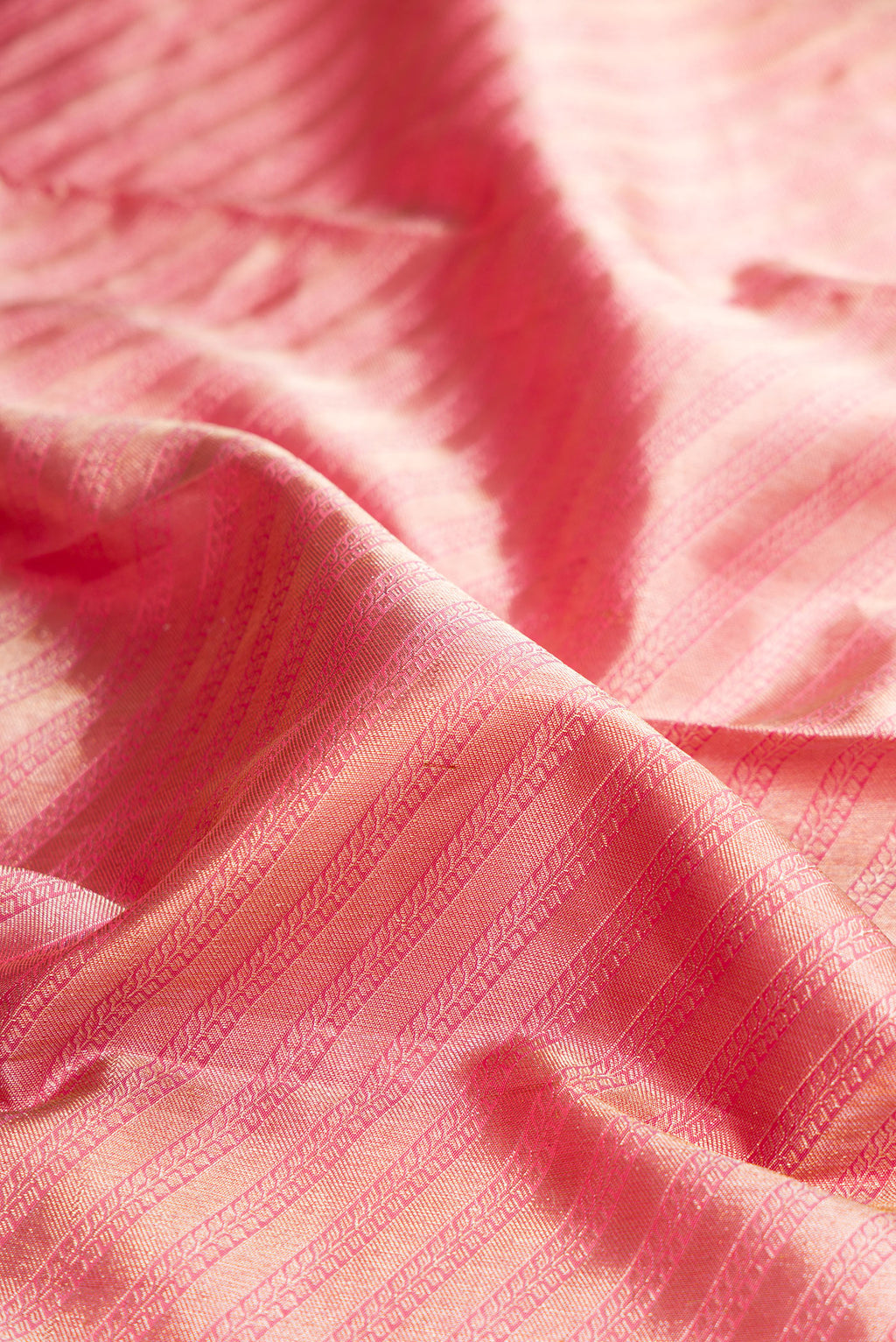 Close up of Pure Silk Rose pink Kanjivaram Saree with Zari Brocade on the body and Fancy Border.  displaying folds