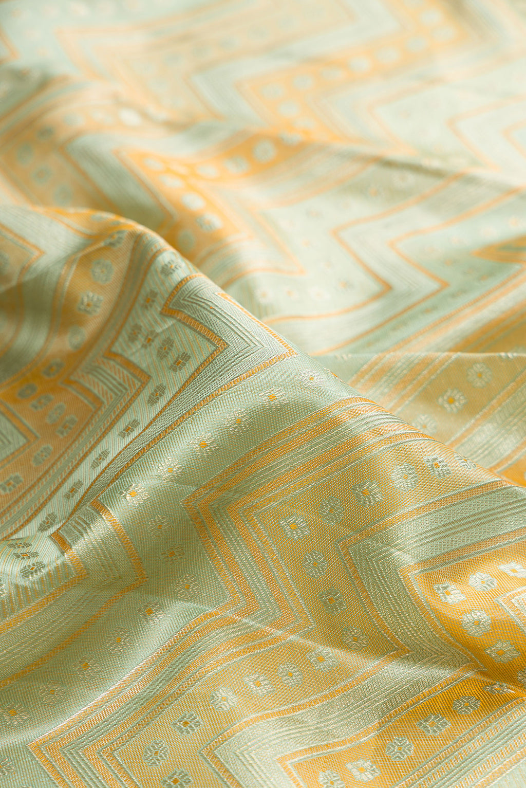 Close up of Pure Silk Light Green Dual Tone Kanjivaram Saree with Zari Brocade on the body and Zari Border.  displaying folds