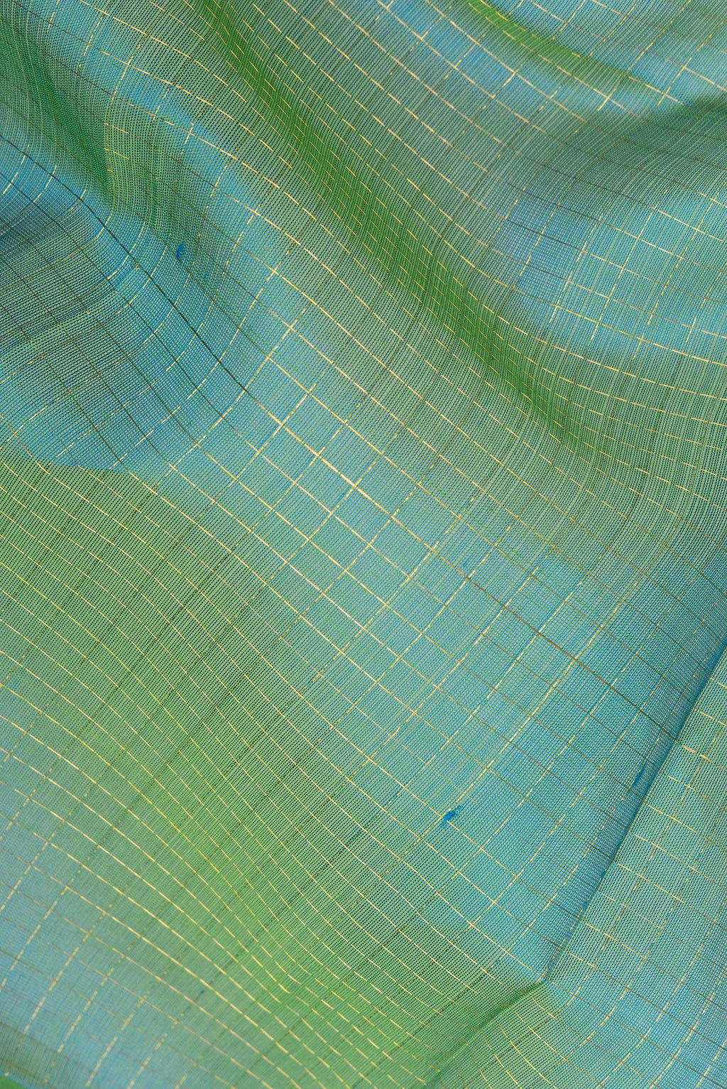 Close up of Green Silk Cotton Saree with Checked design on the body and Zari Border.  displaying folds