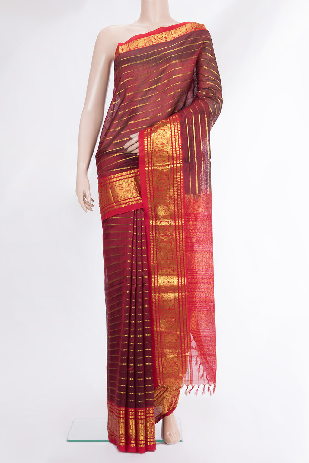 Maroon Silk Cotton Saree with Stripes on the body and Zari Border.  displayed on a mannequin