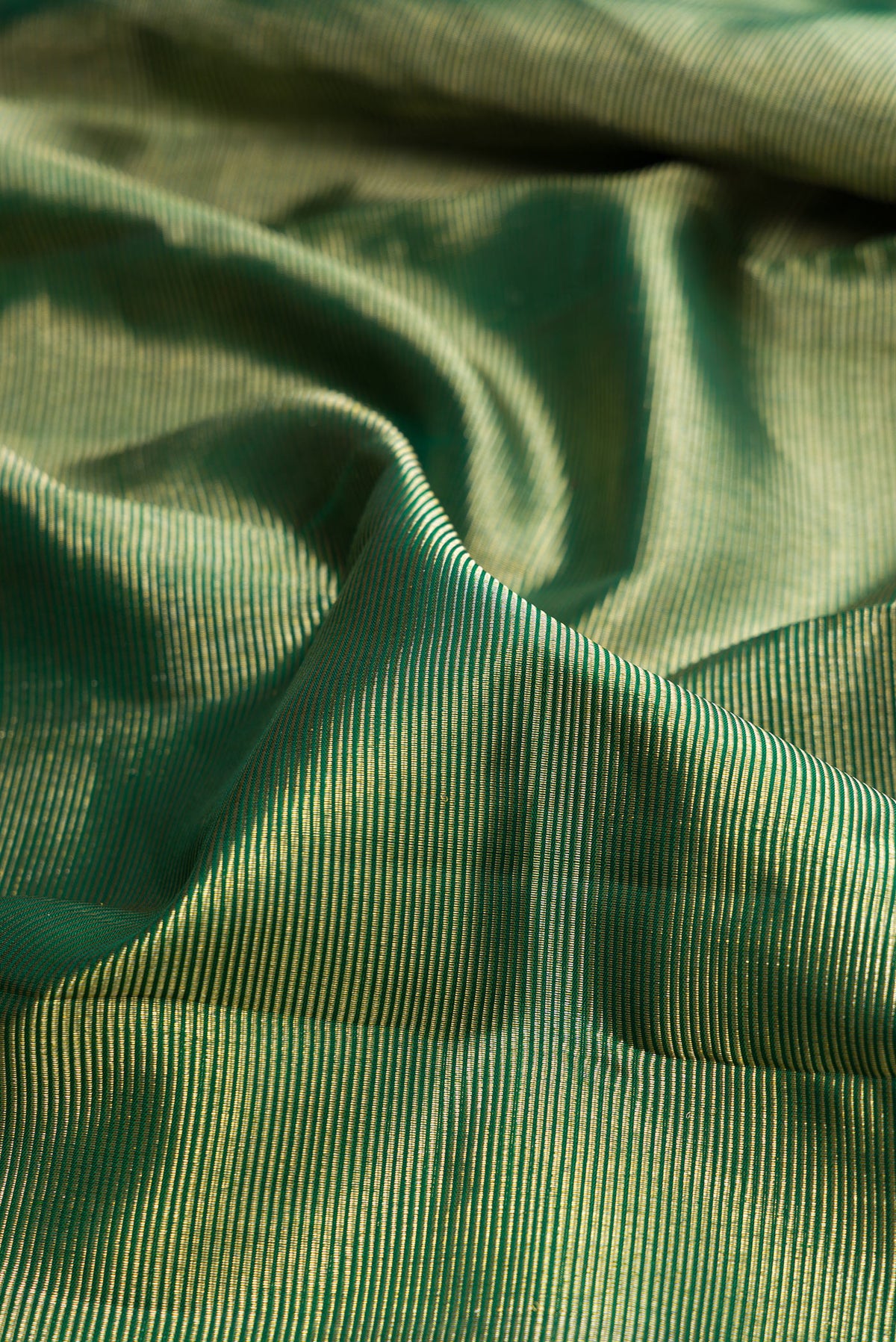 Close up of Pure Silk Green Kanchipuram Saree with Zari Brocade on the body and Temple Border.  displaying folds