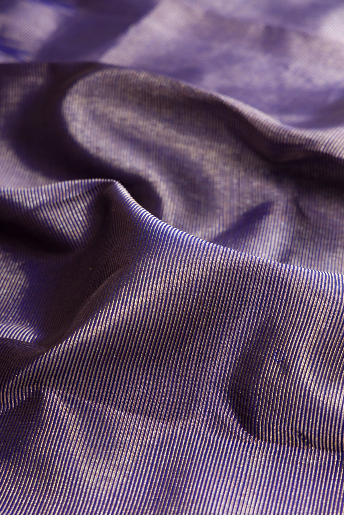 Close up of Pure Silk Royal Blue Dual Tone Kanchipuram Saree with Zari Brocade on the body and Temple Border.  displaying folds