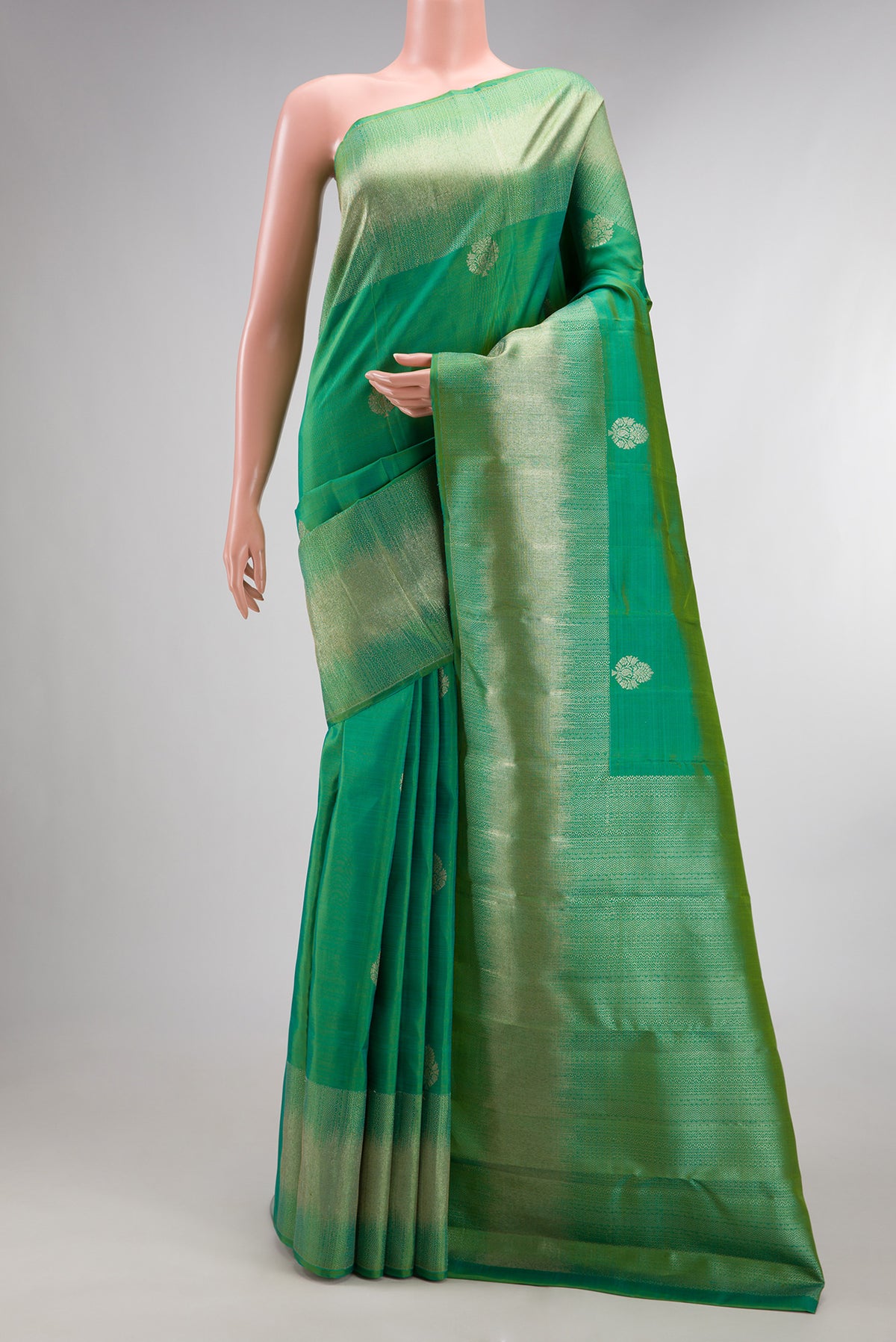 Pure Silk Green Dual Tone Kanjivaram Saree with Zari Butta on the body and Fancy Border.  displayed on a mannequin