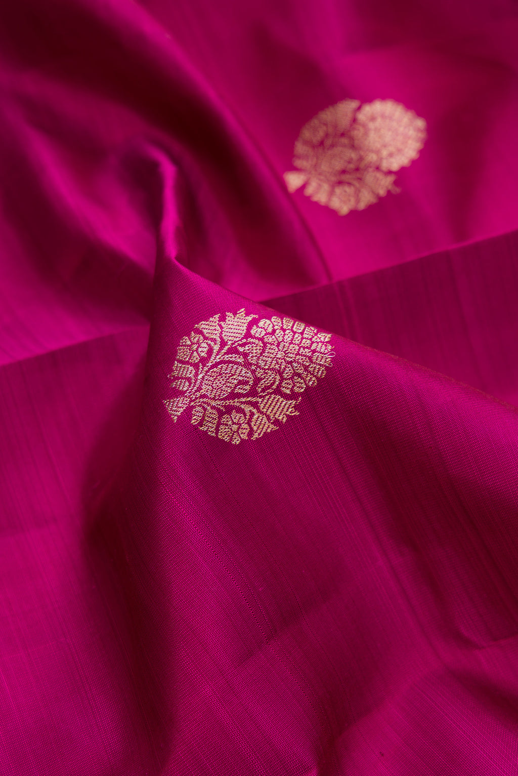 Close up of Pure Silk Magenta Dual Tone Kanjivaram Saree with Zari Butta on the body and Fancy Border.  displaying folds