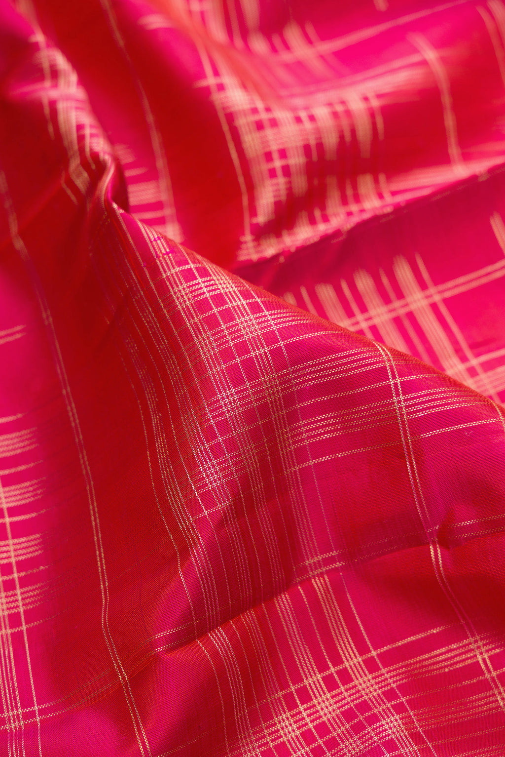 Close up of Pure Silk Dark Pink Kanchipuram Saree with Checked design on the body and Zari Border.  displaying folds