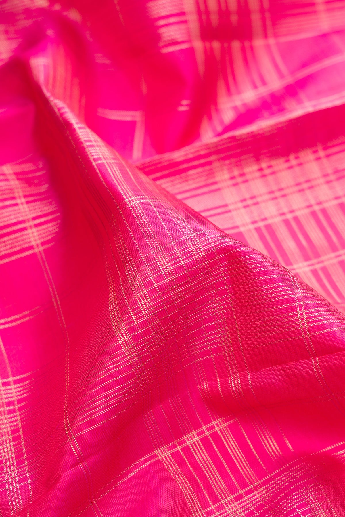 Close up of Pure Silk Pink Kanchipuram Saree with Checked design on the body and Zari Border.  displaying folds